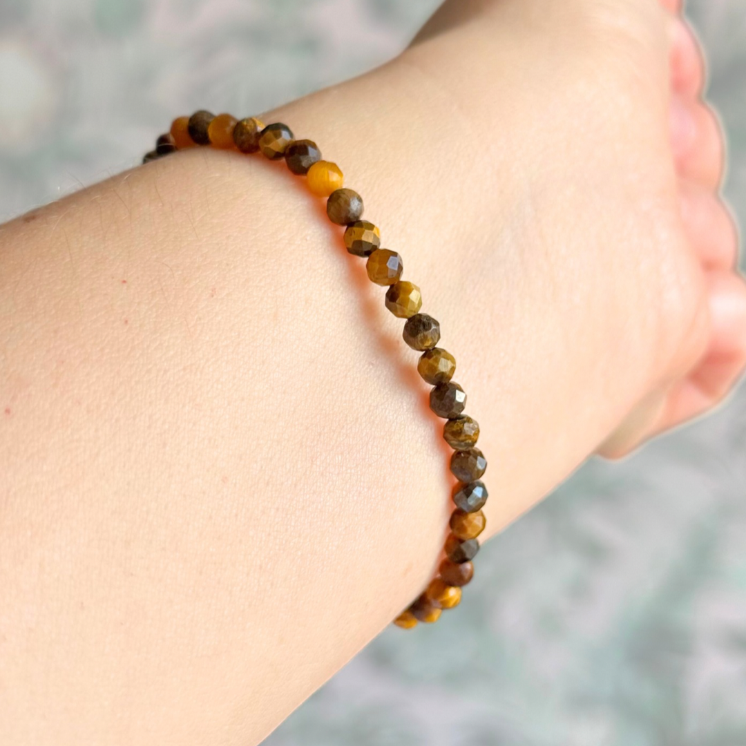 Essential oil diffuser bracelet featuring black lava rock tube bead on the band of 4mm faceted tigers eye beads. Finished with your choice of sterling silver or gold vermeil accent beads.