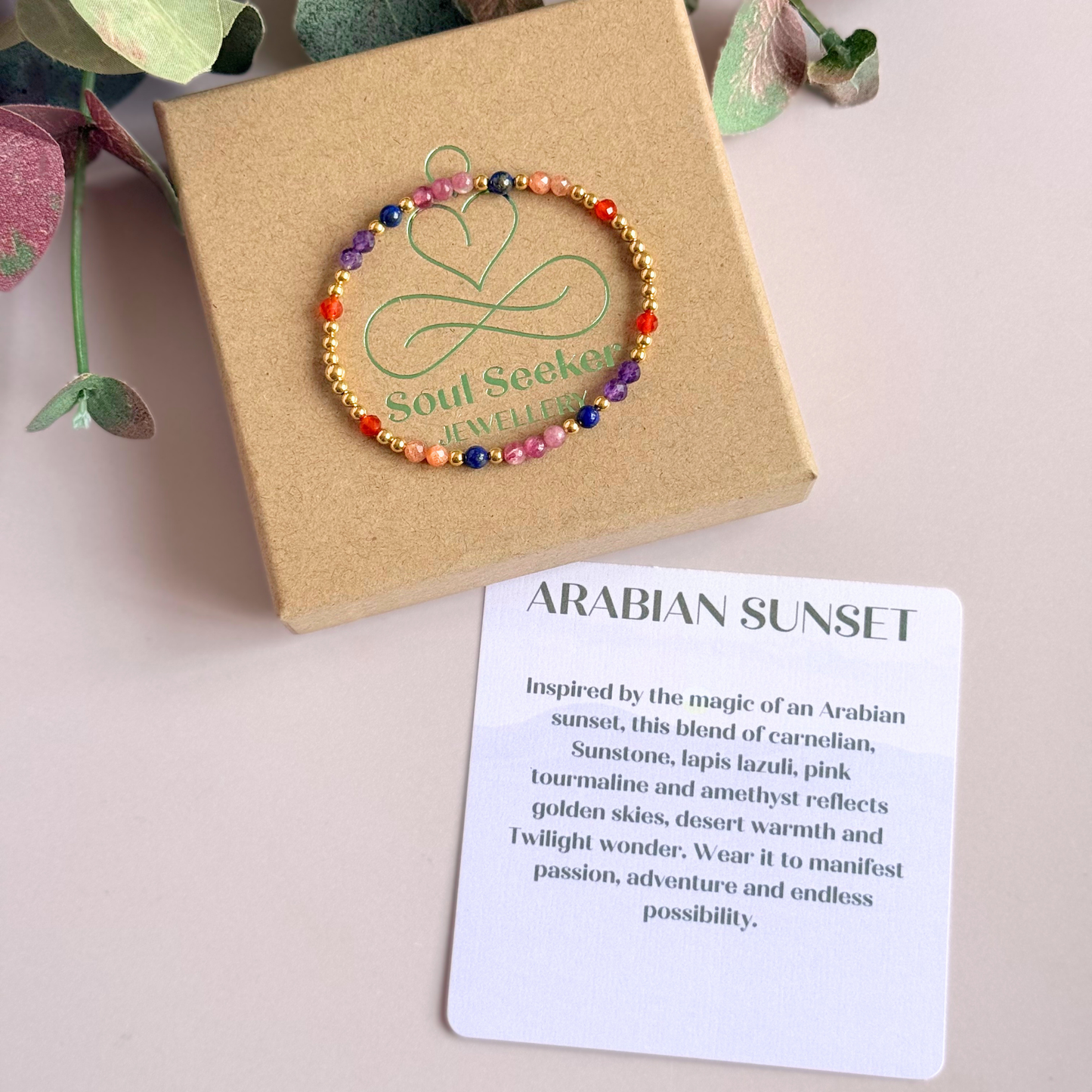 ‘Arabian Sunset' gold vermeil dainty beaded bracelet with pink tourmaline, sunstone, carnelian, lapis lazuli and amethyst. Made with round 3mm gold vermeil beads and 4mm smooth and faceted round crystal gemstone beads. Pictured on top of the gift box, with the crystal information card.