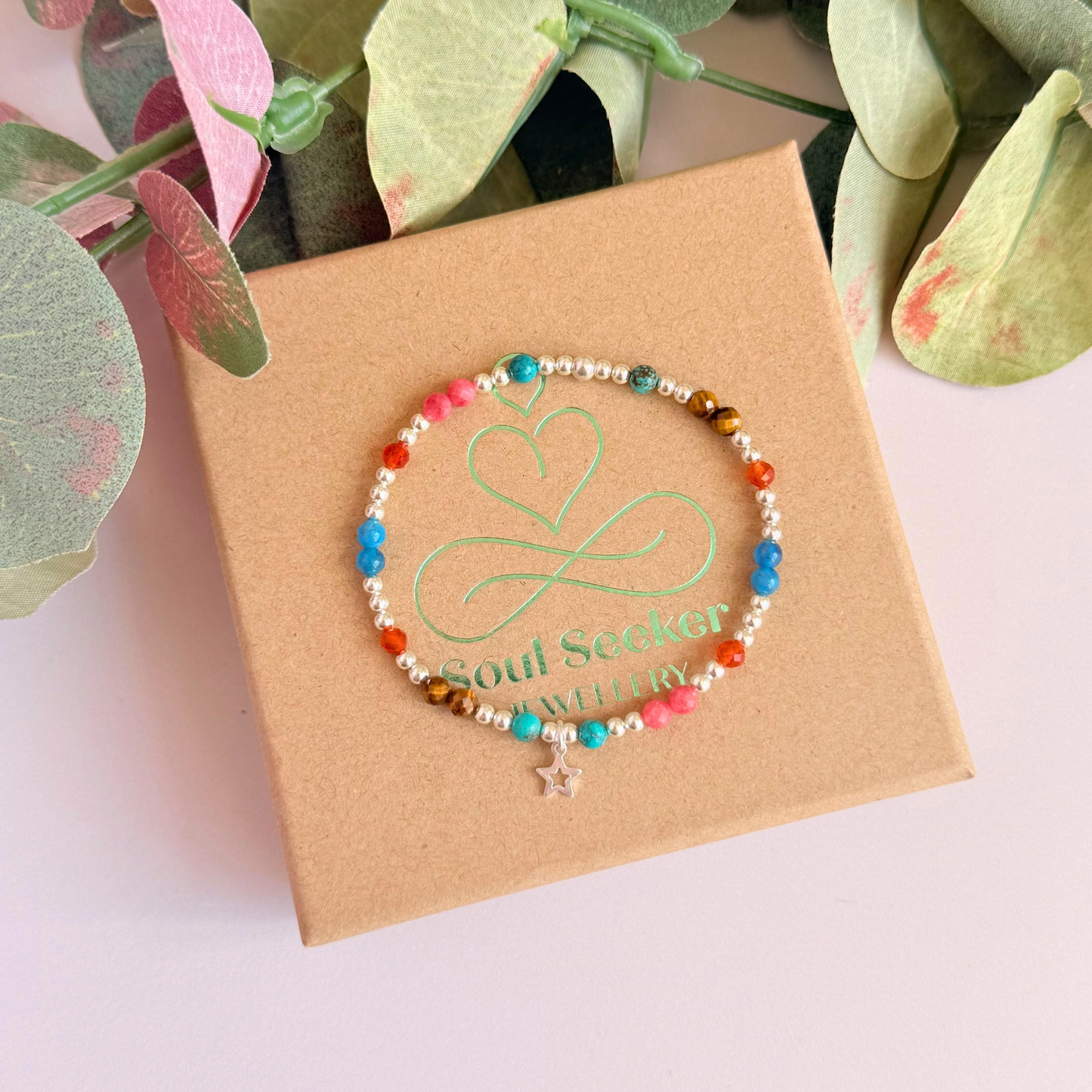 'Hot girl summer' sterling silver dainty beaded bracelet with tigers eye, turquoise, apatite, carnelian and rhodochrosite. With a beautiful open star charm. Made with round 3mm sterling silver beads and 4mm smooth and faceted round crystal gemstone beads. Pictured from above, on the gift box.