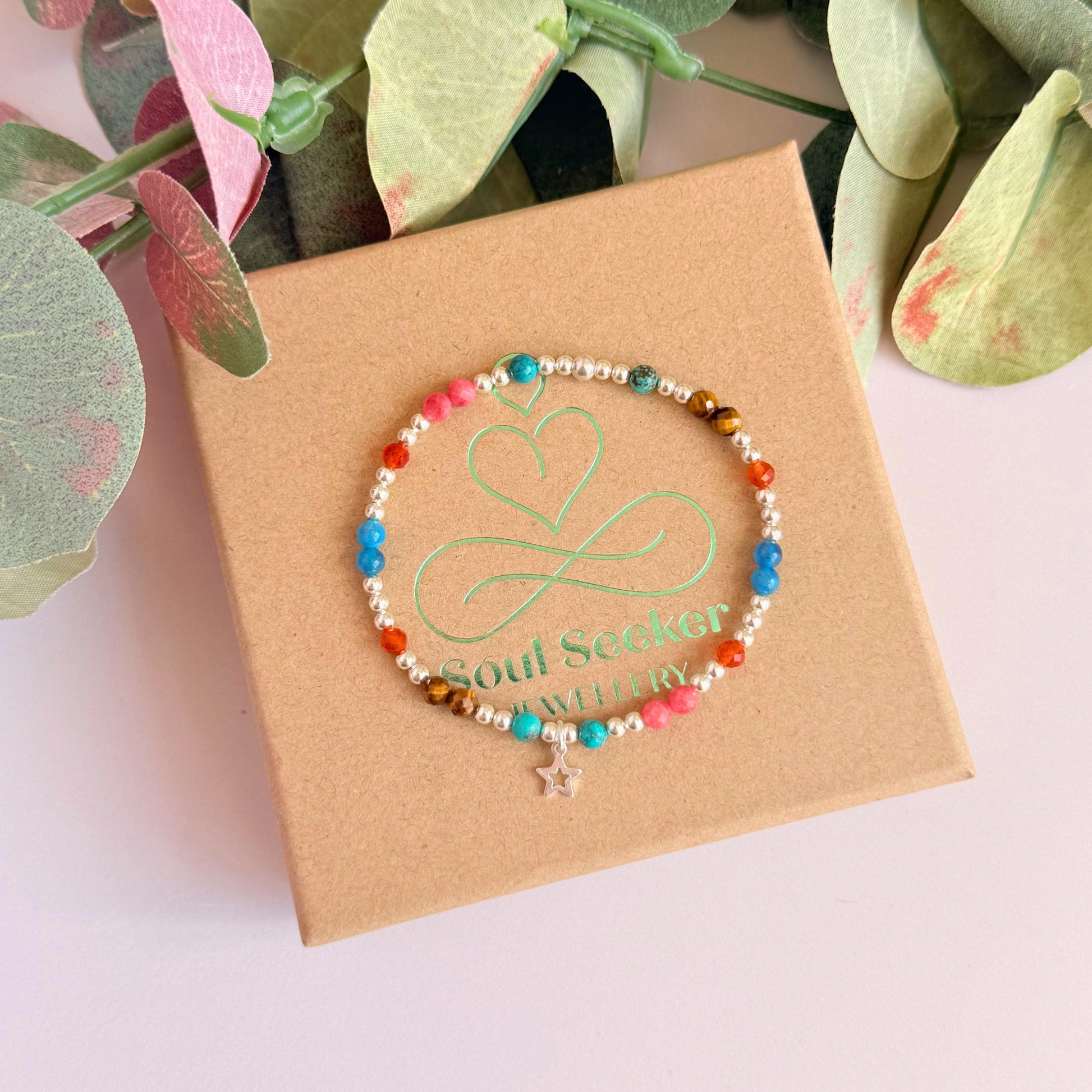 'Hot girl summer' sterling silver dainty beaded bracelet with tigers eye, turquoise, apatite, carnelian and rhodochrosite. With a beautiful open star charm. Made with round 3mm sterling silver beads and 4mm smooth and faceted round crystal gemstone beads. Pictured from above, on the gift box.