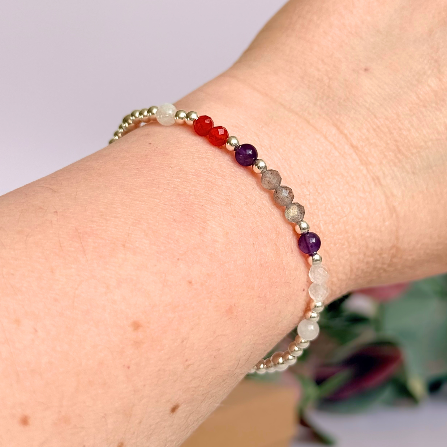 Dainty sterling silver crystal bracelet featuring five crystals, in 4mm faceted and smooth round style, each believed to help with hormonal balance. Featuring amethyst, moonstone, carnelian, labradorite and rose quartz. Pictured being worn.
