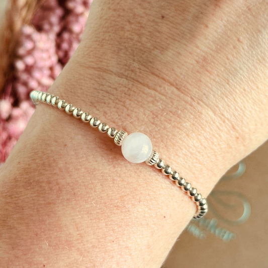 sterling silver rose quartz  bracelet features an ethically mined 8mm rose quartz bead, flanked by corrugated rondelle beads on a band of 3mm sterling silver beads. A bracelet to promote self love and self-confidence.