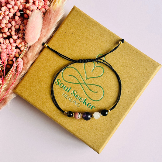 Cord bracelet made with five crystals all believed to help with grief and bereavement. Including smoky quartz, amethyst, rose quartz, rhodonite and black onyx. With your choice of cord colour and choice of either sterling silver, gold vermeil or rose gold vermeil accent beads.