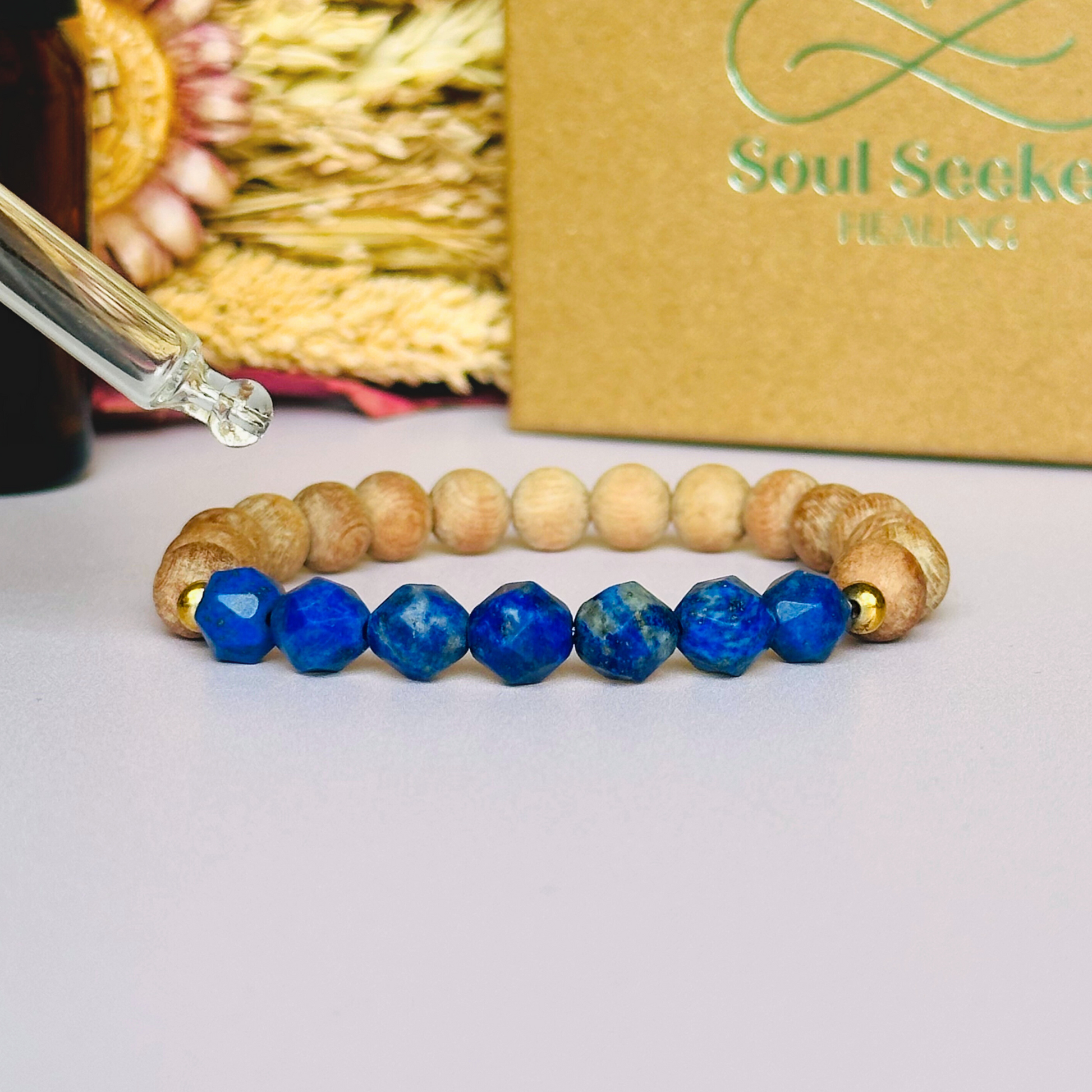Lapis lazuli and raw rosewood elasticated essential oil diffuser bracelet. Made with 8mm star cut lapis lazuli beads, 8mm round raw rosewood beads and your choice of sterling silver, gold vermeil or rose gold vermeil spacer beads