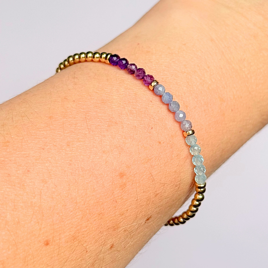 Dainty minimalist yellow gold filled crystal bracelet featuring 3mm faceted amethyst, aquamarine and tanzanite beads in a colour block Ombre style. Fastens with a gold filled lobster clasp with an extender chain.
