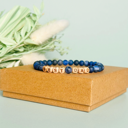 Men’s crystal bracelet with 6mm frosted sodalite gemstone crystal beads and laser engraved wooden letter beads featuring the words best dad or can also be made with any other words or letters.