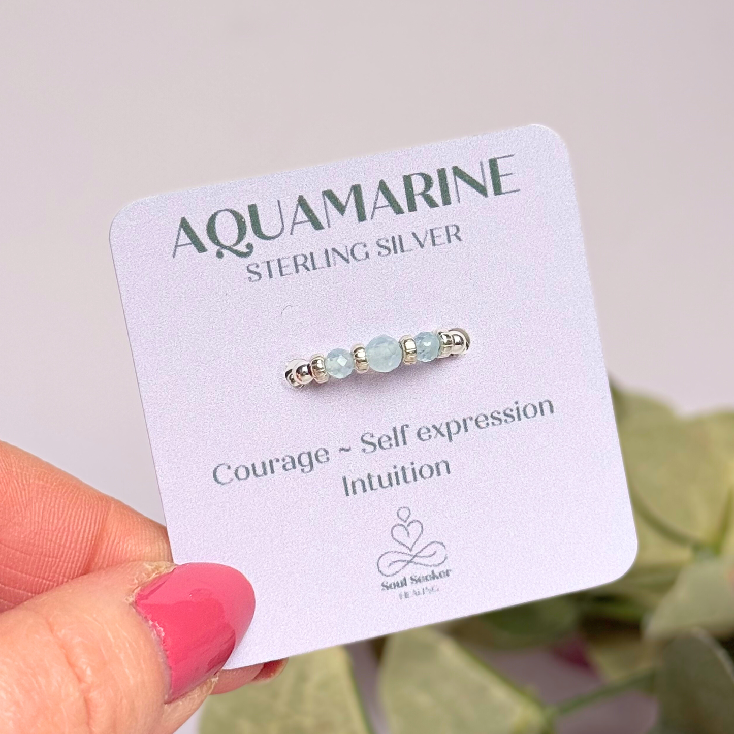 Aquamarine crystal trilogy sterling silver elasticated ring featuring three March birthstone gemstone faceted beads, on a band of sterling silver round beads. The crystals are seperated by sterling silver corrugated rondelles. The main crystal is 4mm and the ones at either side are 3mm. Shown on the display card.