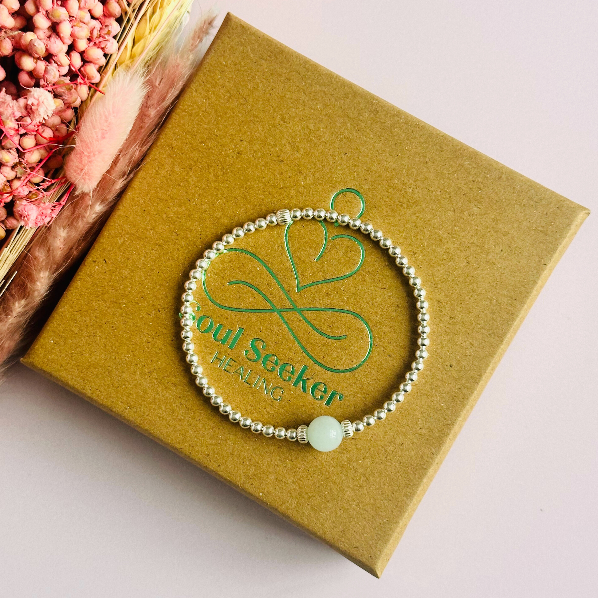 Sterling silver aquamarine bracelet features an ethically mined 8mm aquamarine bead, flanked by corrugated rondelle beads on a band of 3mm sterling silver beads. A bracelet to promote courage and self expression.