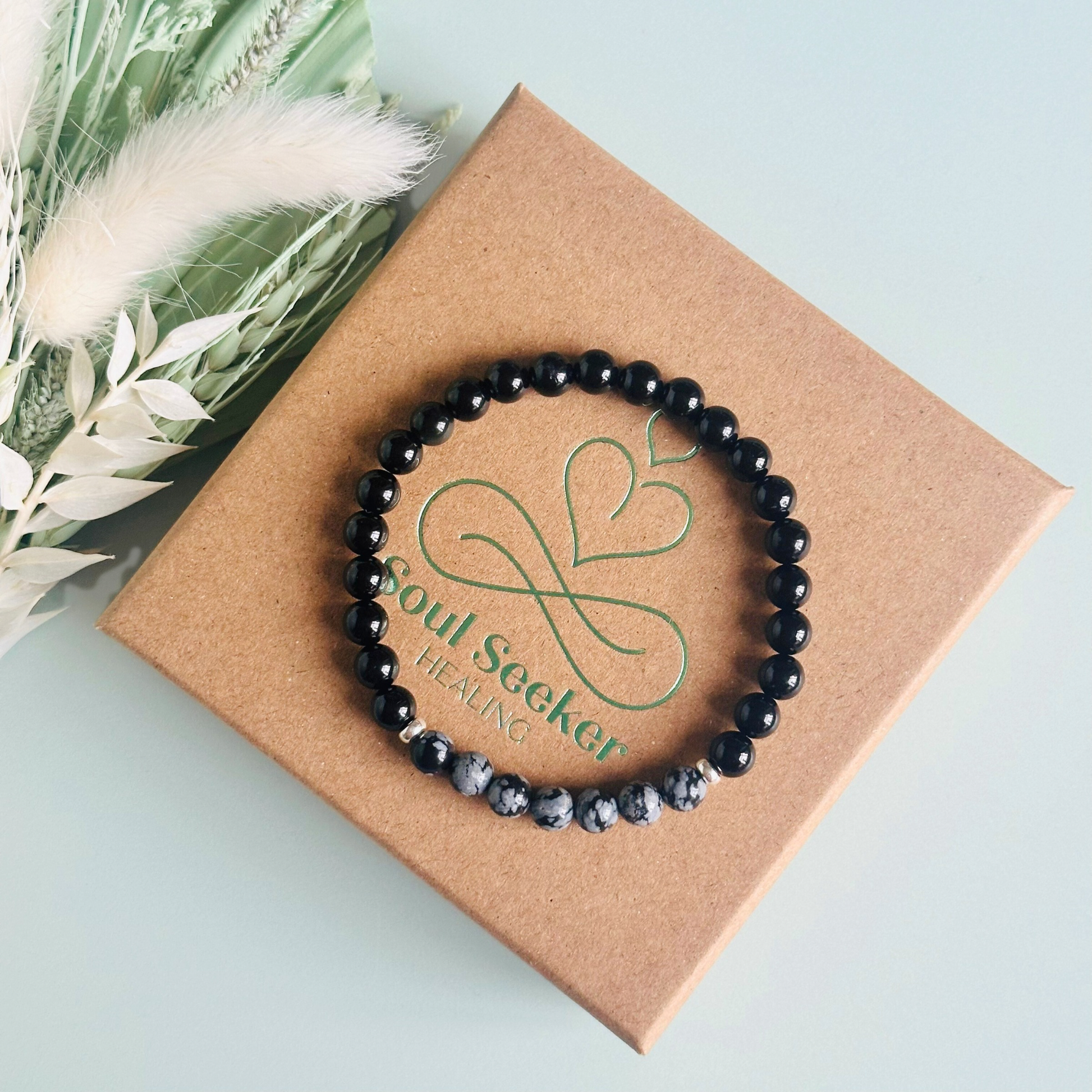 Men’s crystal bracelet featuring 6mm black tourmaline beads, 6mm snowflake obsidian beads with sterling silver spacer beads.