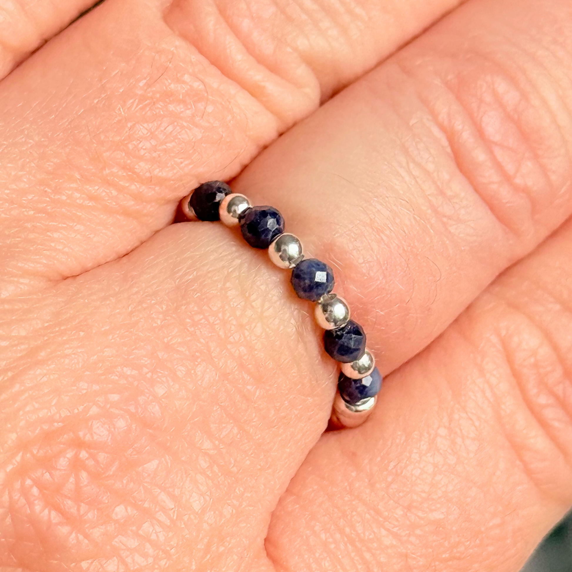 Sterling silver and sapphire crystal ring. Made with 2.5 mm sterling silver round beads and featuring five, 3mm faceted genuine sapphire beads in a band style. Perfect for stacking. September birthstone jewellery