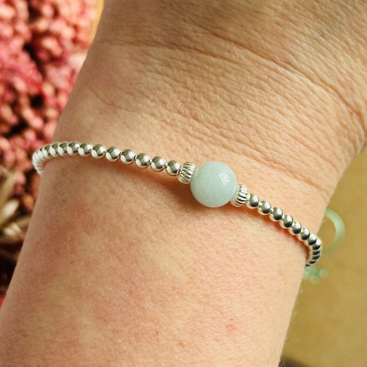 Sterling silver aquamarine bracelet features an ethically mined 8mm aquamarine bead, flanked by corrugated rondelle beads on a band of 3mm sterling silver beads. A bracelet to promote courage and self expression.