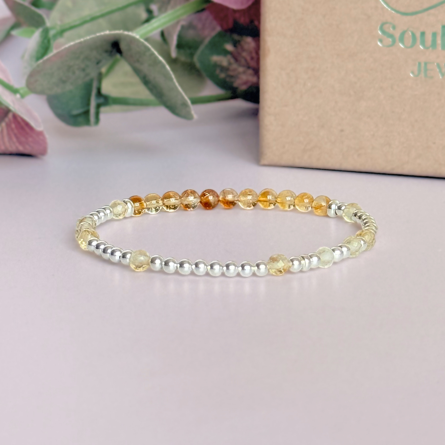 Citrine morse code bracelet that spells out the words ‘Ask, believe, receive’ in a combination of 4mm round smooth and faceted crystal beads with your choice of sterling silver or gold vermeil accent beads. Pictured in silver, in front of the gift box