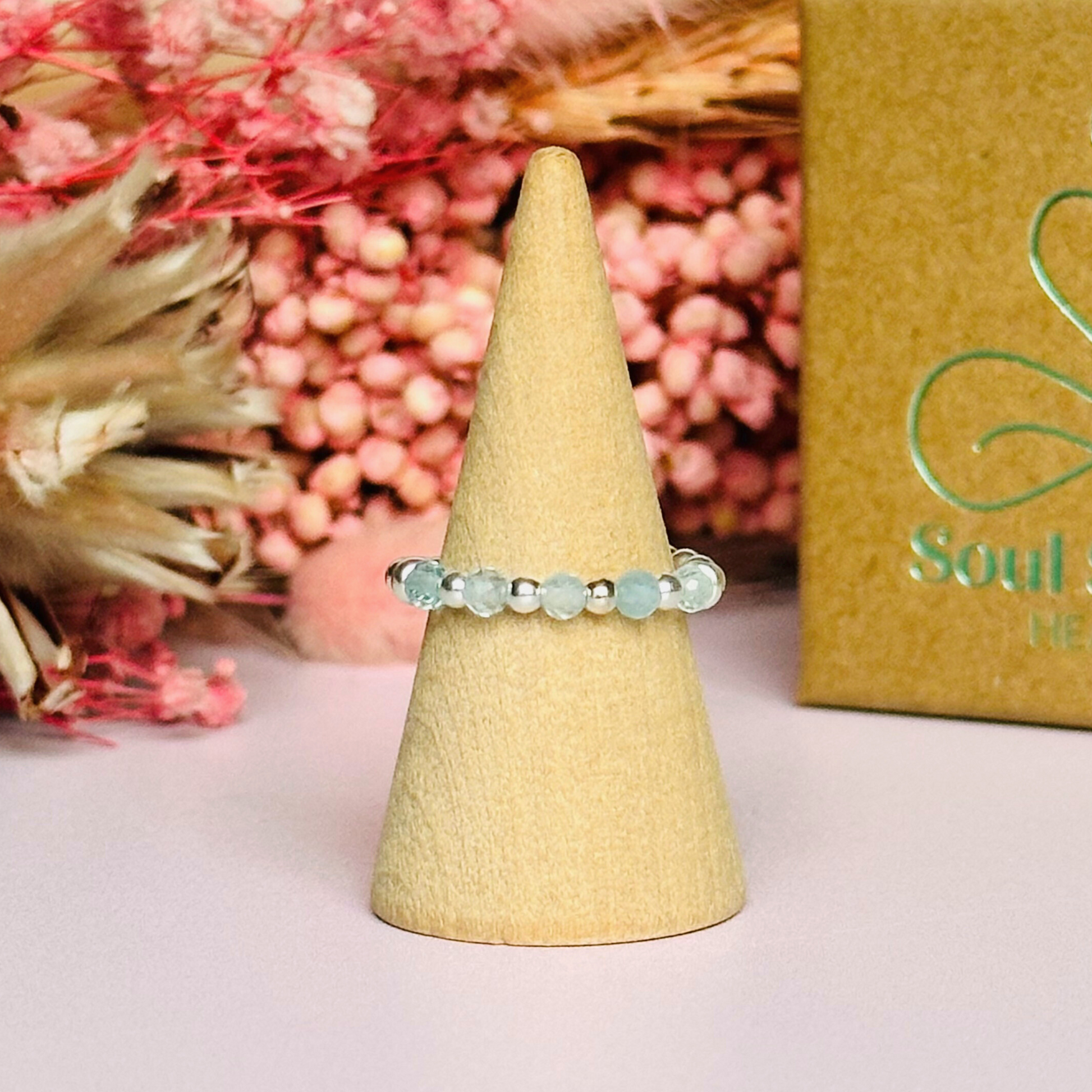 Sterling silver aquamarine ring featuring five 3mm faceted round aquamarine beads on a elasticated ring band of 2.5mm gold vermeil beads. March birthstone ring.