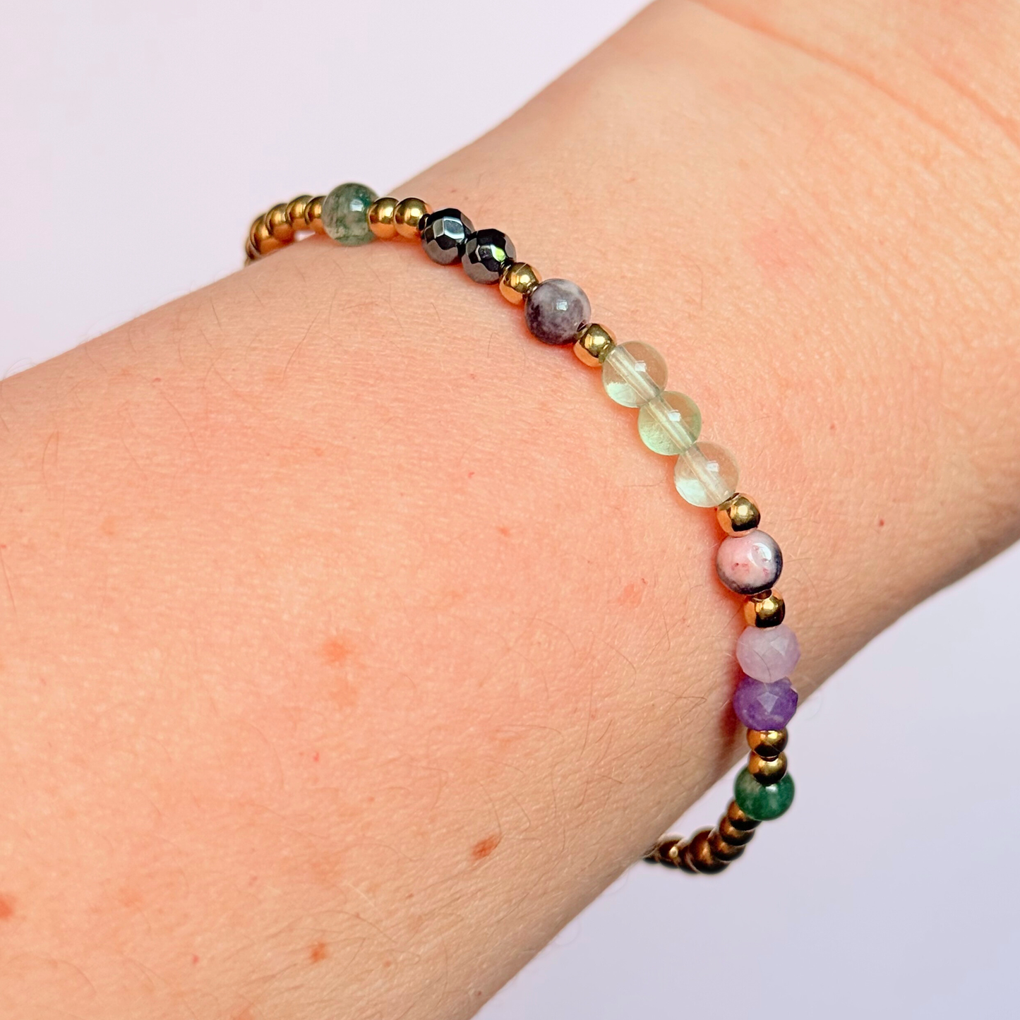 Dainty crystal bracelet featuring five crystals all believed to help with focus, clarity and overwhelm. Featuring fluorite, hematite, lepidolite, moss agate and pink zebra jasper. Featuring 3mm gold vermeil round beads and 4mm faceted round and smooth round crystal beads. Pictured being worn.