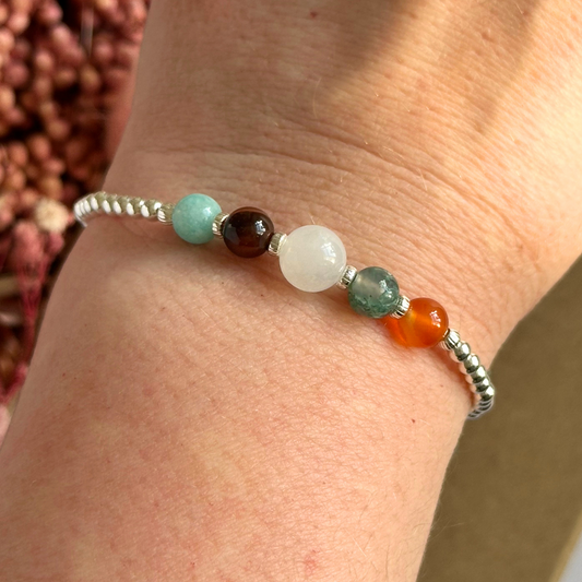 This sterling silver Virgo bracelet is made with a selection of five healing crystals all believed to resonate with the Virgo zodiac sign. The central bead is 8mm, the other four are 6mm. On an elasticated band of 3mm sterling silver beads with corrugated accent beads. Featuring amazonite, carnelian, moonstone, moss agate and sardonyx.