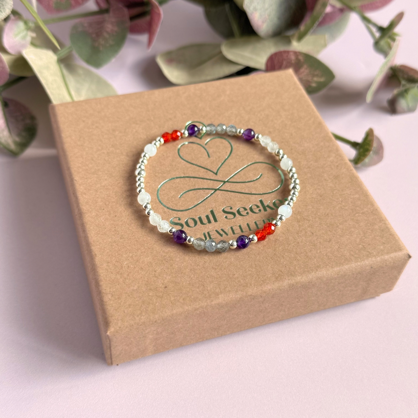 Dainty sterling silver crystal bracelet featuring five crystals, in 4mm faceted and smooth round style, each believed to help with hormonal balance. Featuring amethyst, moonstone, carnelian, labradorite and rose quartz. Pictured on top of the gift box.