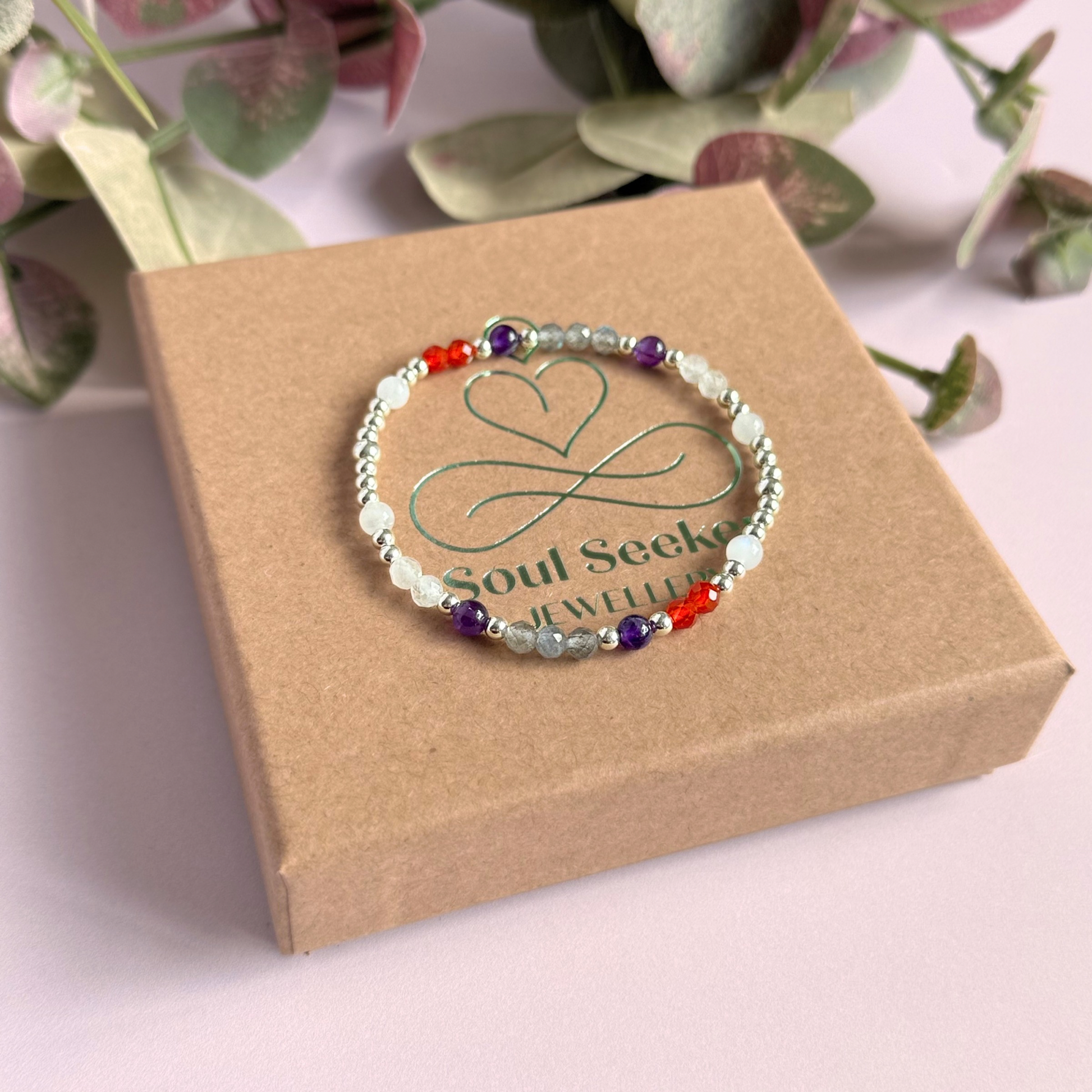 Dainty sterling silver crystal bracelet featuring five crystals, in 4mm faceted and smooth round style, each believed to help with hormonal balance. Featuring amethyst, moonstone, carnelian, labradorite and rose quartz. Pictured on top of the gift box.