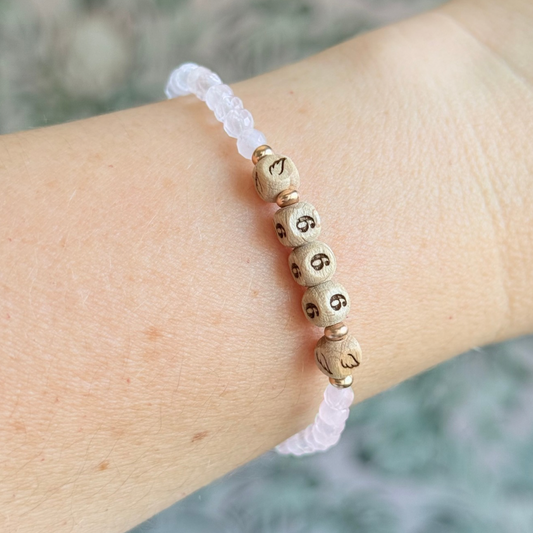 Bracelet featuring engraved wooden 666 angel number and wing beads, on the band of 4mm faceted rose quartz round crystal gemstone beads. Finished with your choice of gold vermeil, sterling silver or rose gold vermeil accent beads.