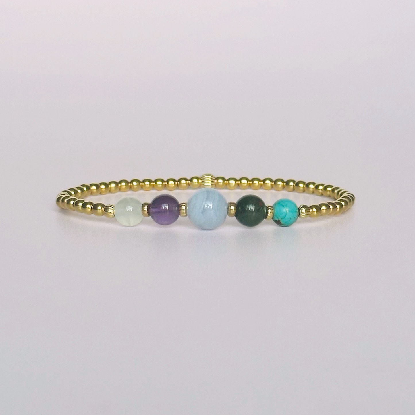 This gold vermeil Pisces bracelet is made with a selection of five healing crystals all believed to resonate with the Pisces zodiac sign. The central bead is 8mm, the other four are 6mm. On an elasticated band of 3mm gold vermeil beads with corrugated accent beads. Featuring turquoise, bloodstone, blue lace agate, amethyst and selenite.