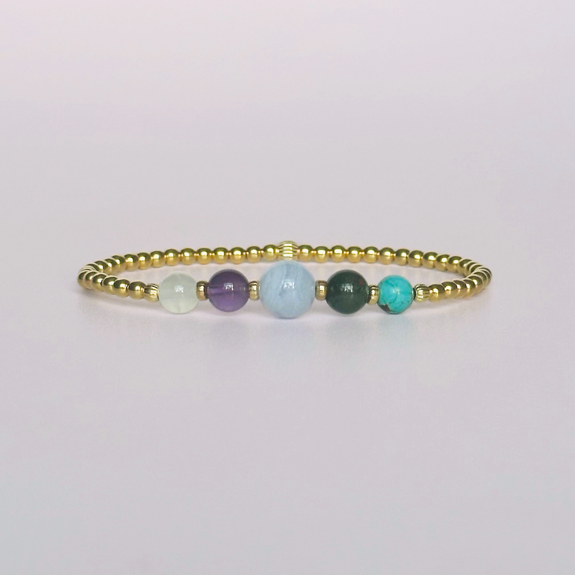 This gold vermeil Pisces bracelet is made with a selection of five healing crystals all believed to resonate with the Pisces zodiac sign. The central bead is 8mm, the other four are 6mm. On an elasticated band of 3mm gold vermeil beads with corrugated accent beads. Featuring turquoise, bloodstone, blue lace agate, amethyst and selenite.