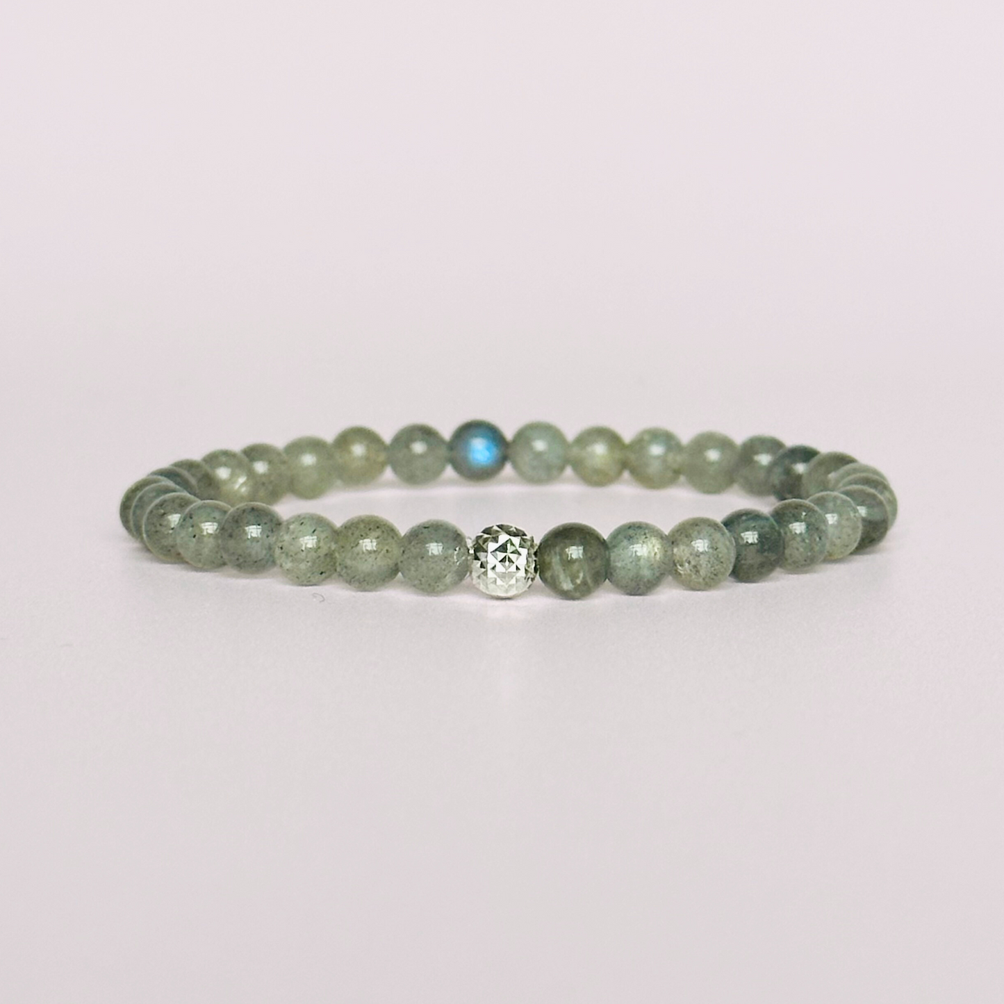 This labradorite bracelet is made with ethically mined labradorite smooth crystal beads and features your choice of a sterling silver or gold vermeil faceted focal bead. All beads are 6mm.