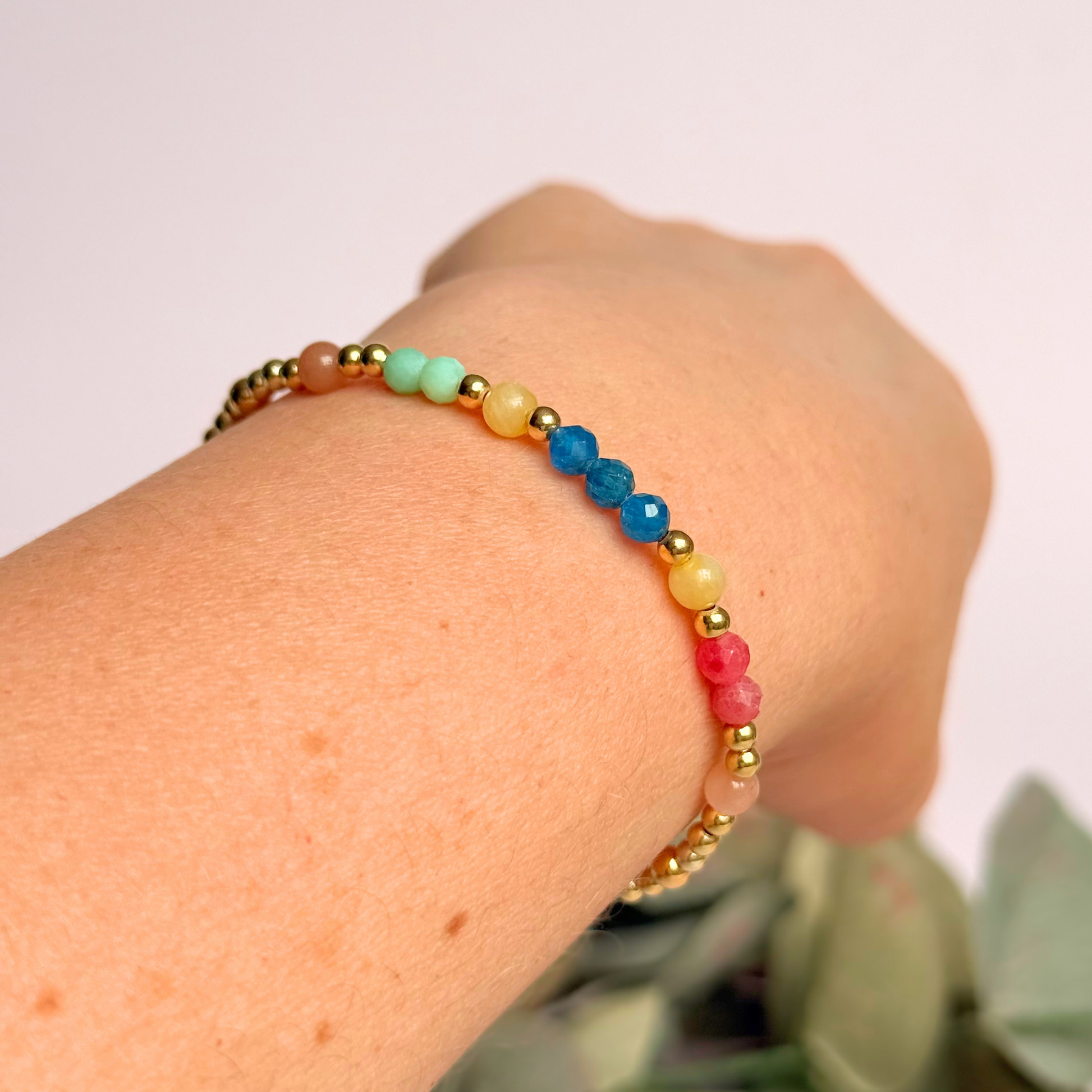 'Key West' gold vermeil dainty beaded bracelet with apatite, rhodochrosite, yellow calcite, chrysoprase and peach moonstone. Made with round 3mm gold vermeil beads and 4mm smooth and faceted round crystal gemstone beads. Pictured being worn, at an angle.