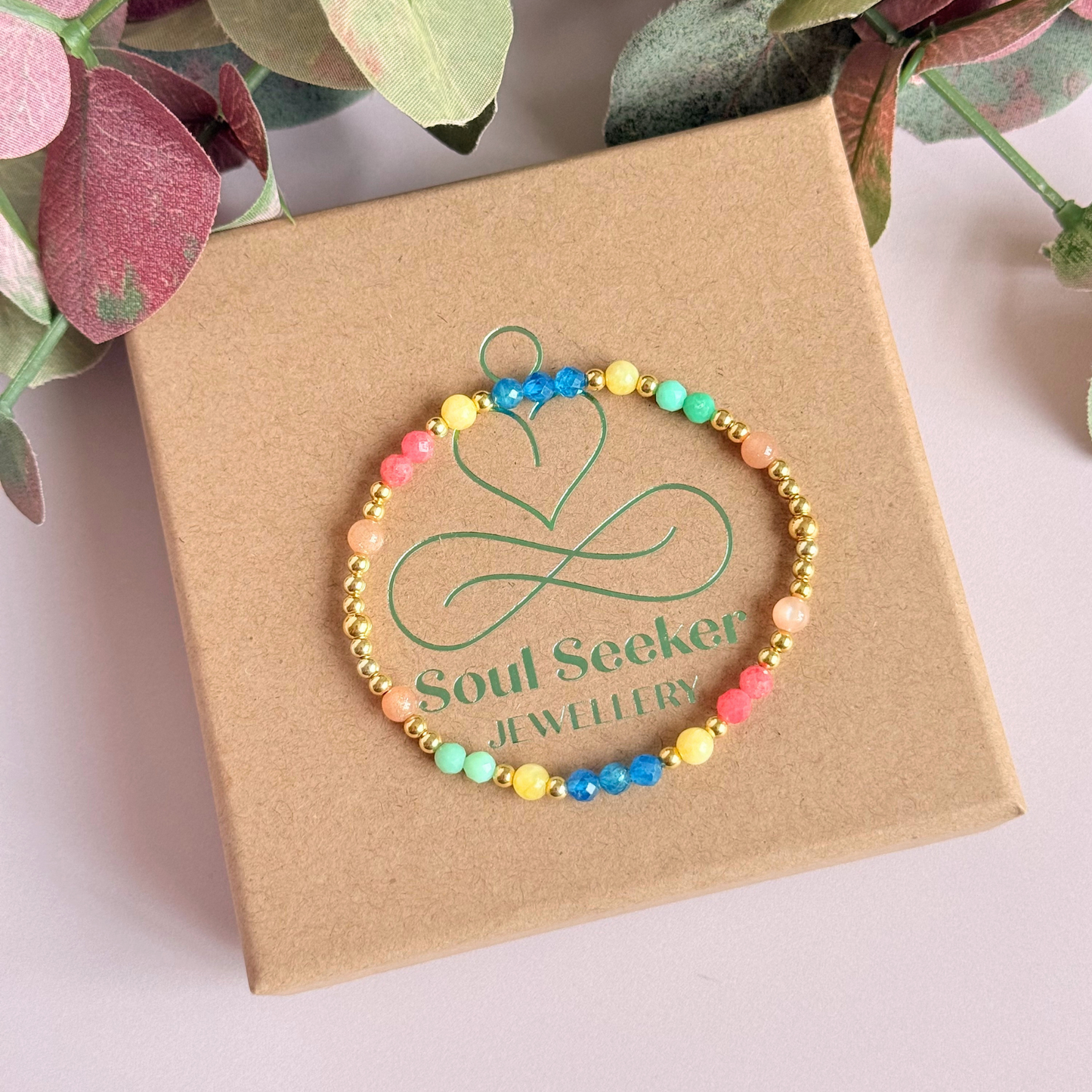 'Key West' gold vermeil dainty beaded bracelet with apatite, rhodochrosite, yellow calcite, chrysoprase and peach moonstone. Made with round 3mm gold vermeil beads and 4mm smooth and faceted round crystal gemstone beads. Pictured from above, on top of the gift box