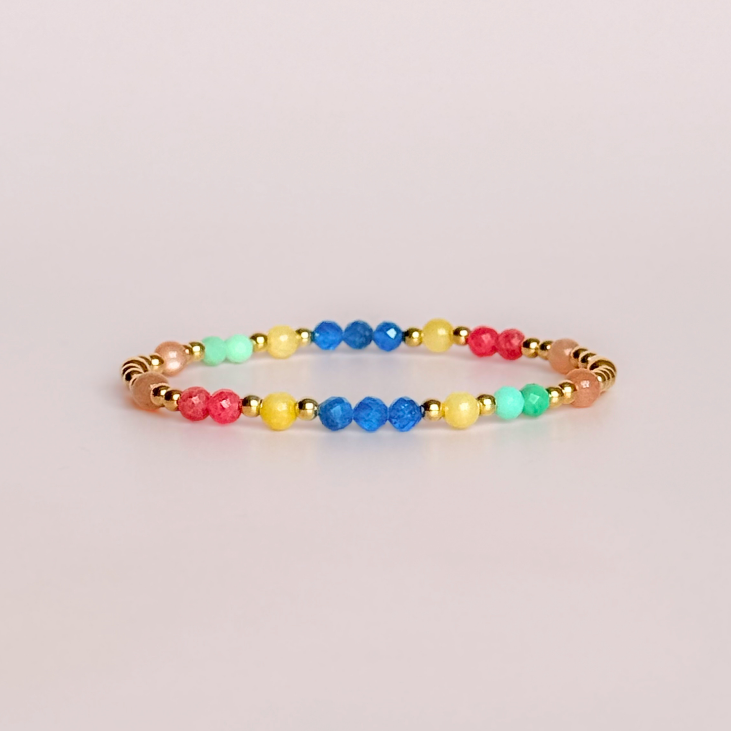 'Key West' gold vermeil dainty beaded bracelet with apatite, rhodochrosite, yellow calcite, chrysoprase and peach moonstone. Made with round 3mm gold vermeil beads and 4mm smooth and faceted round crystal gemstone beads. Pictured against a pink background