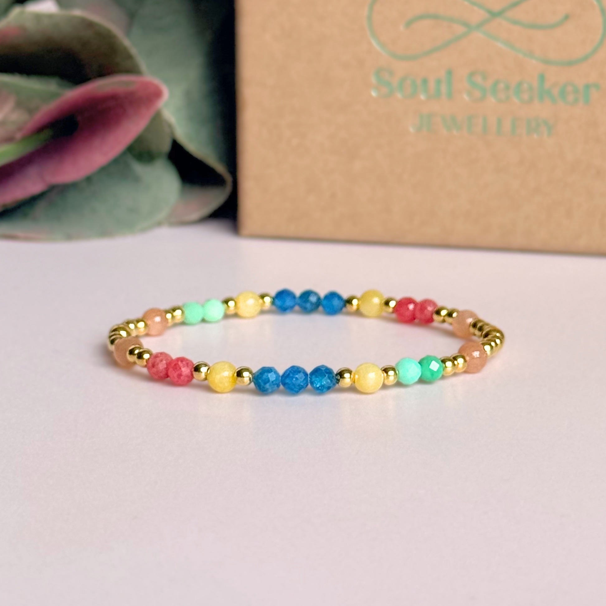 'Key West' gold vermeil dainty beaded bracelet with apatite, rhodochrosite, yellow calcite, chrysoprase and peach moonstone. Made with round 3mm gold vermeil beads and 4mm smooth and faceted round crystal gemstone beads. Pictured in front of the gift box