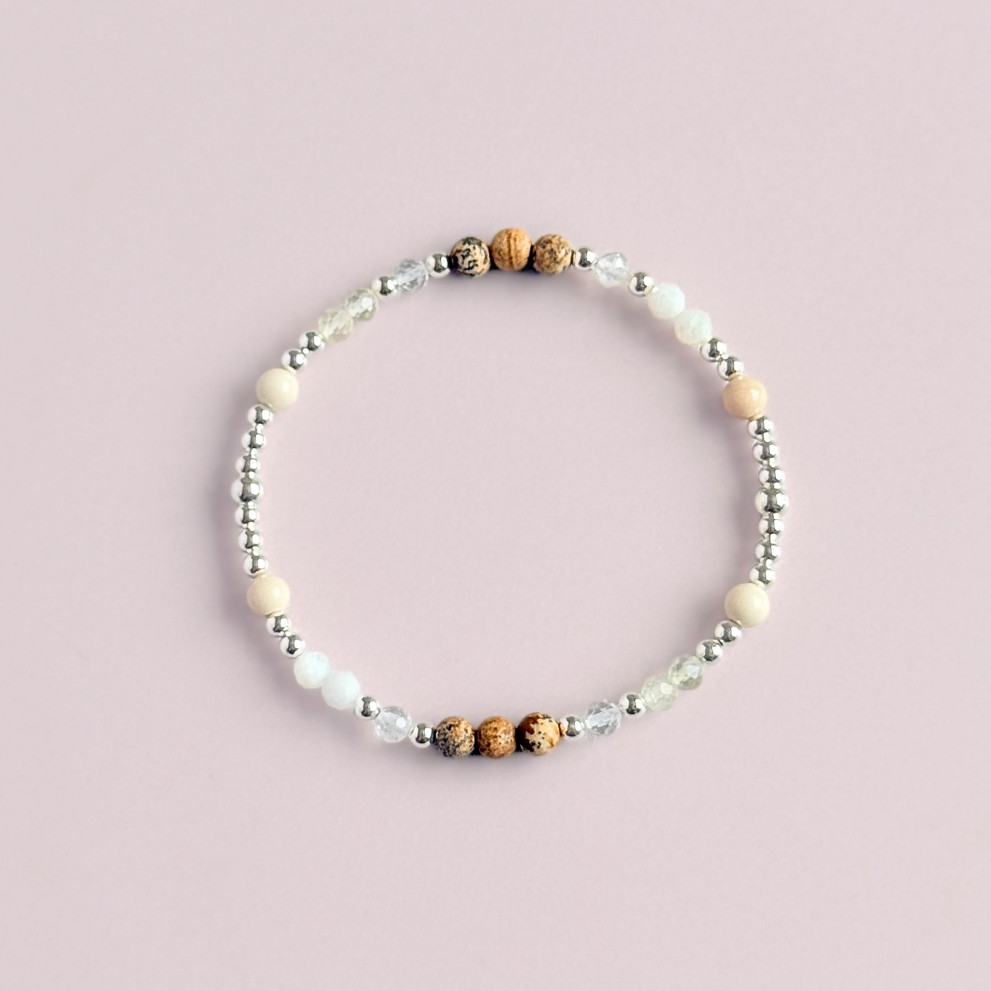 'Ibiza Bohemia' sterling silver dainty beaded bracelet with picture jasper, river stone jasper, citrine, clear quartz and moonstone. Made with round 3mm sterling silver beads and 4mm smooth and faceted round crystal gemstone beads. Pictured from above, against a pink background.