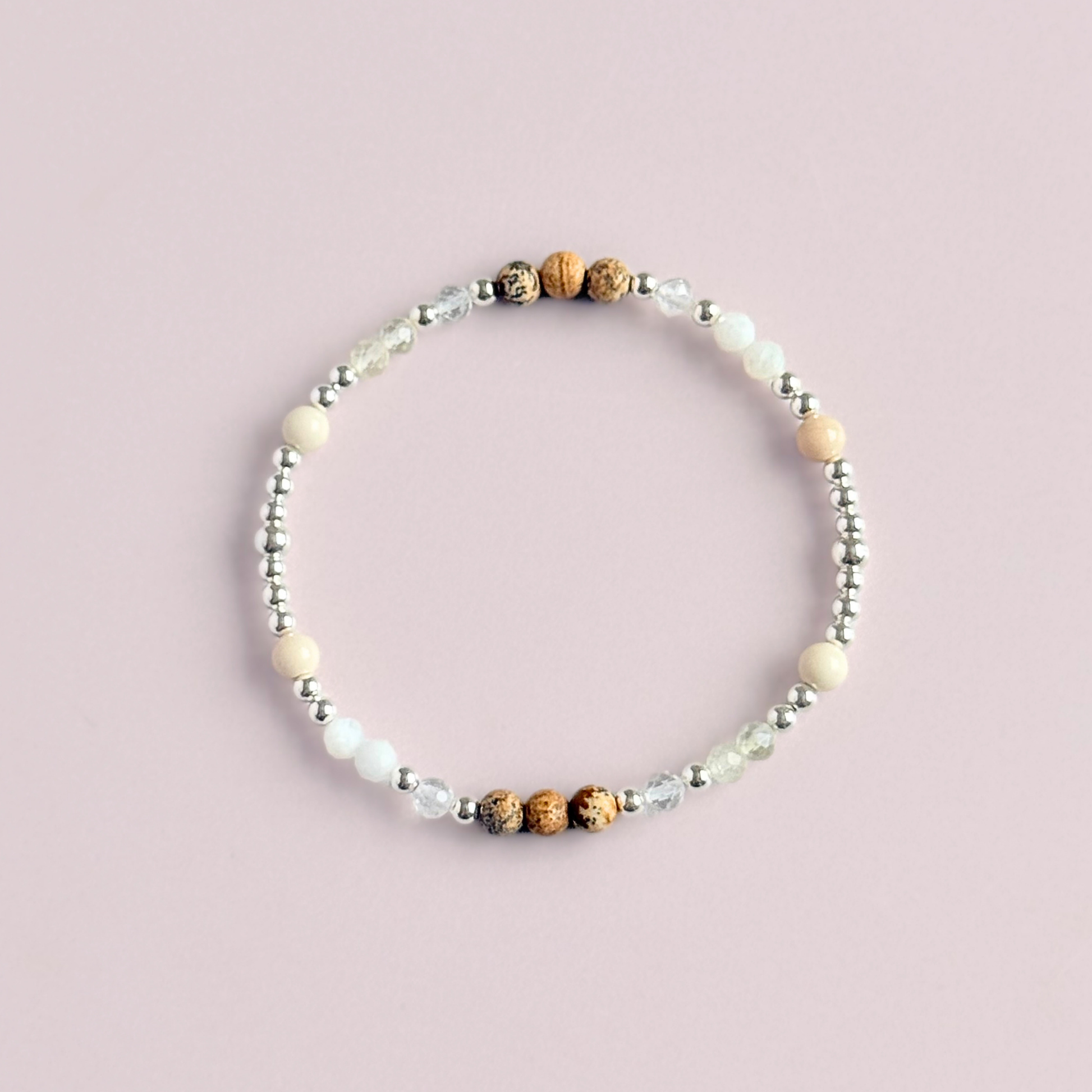 'Ibiza Bohemia' sterling silver dainty beaded bracelet with picture jasper, river stone jasper, citrine, clear quartz and moonstone. Made with round 3mm sterling silver beads and 4mm smooth and faceted round crystal gemstone beads. Pictured from above, against a pink background.