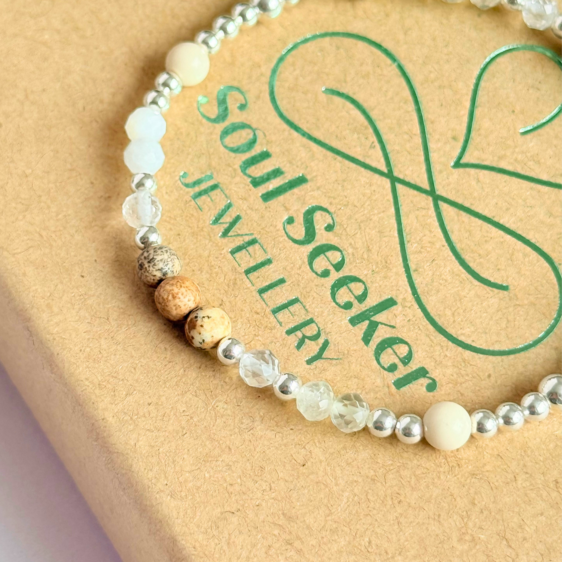 'Ibiza Bohemia' sterling silver dainty beaded bracelet with picture jasper, river stone jasper, citrine, clear quartz and moonstone. Made with round 3mm sterling silver beads and 4mm smooth and faceted round crystal gemstone beads. Pictured close up, on the box.
