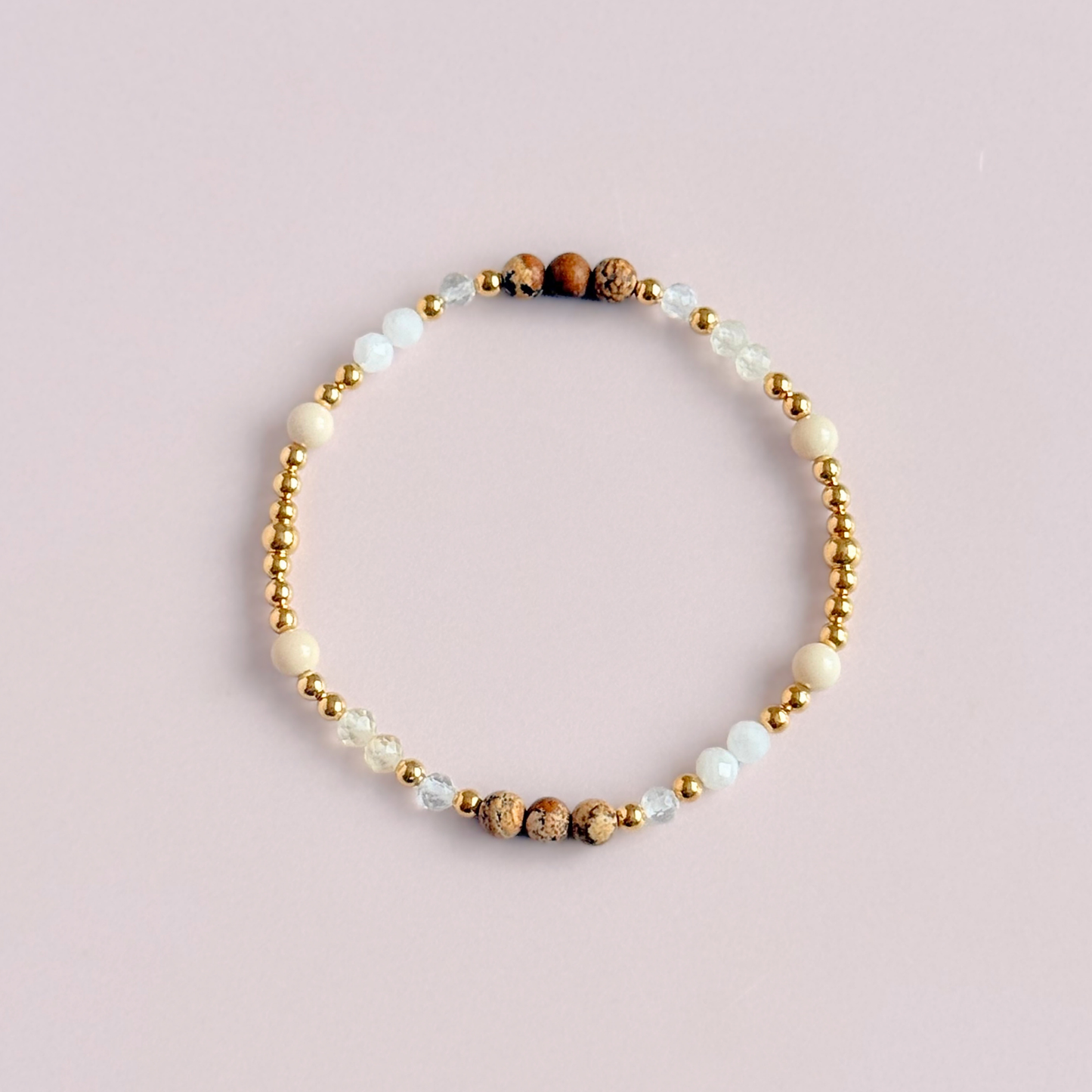 'Ibiza Bohemia' gold vermeil dainty beaded bracelet with picture jasper, river stone jasper, citrine, clear quartz and moonstone. Made with round 3mm gold vermeil beads and 4mm smooth and faceted round crystal gemstone beads. Pictured from above, against a pink background.