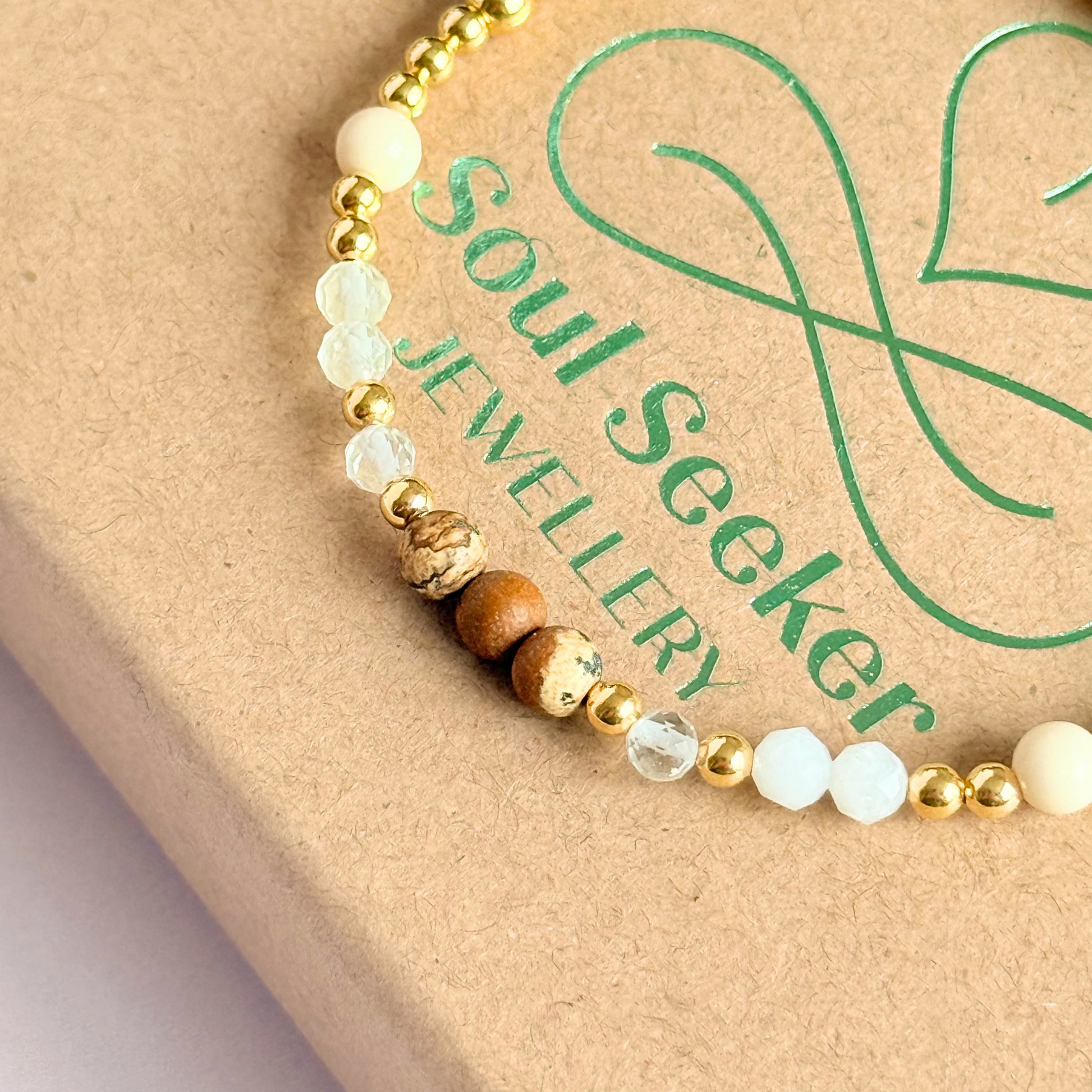 'Ibiza Bohemia' gold vermeil dainty beaded bracelet with picture jasper, river stone jasper, citrine, clear quartz and moonstone. Made with round 3mm gold vermeil beads and 4mm smooth and faceted round crystal gemstone beads. Pictured close up, on top of the gift box.