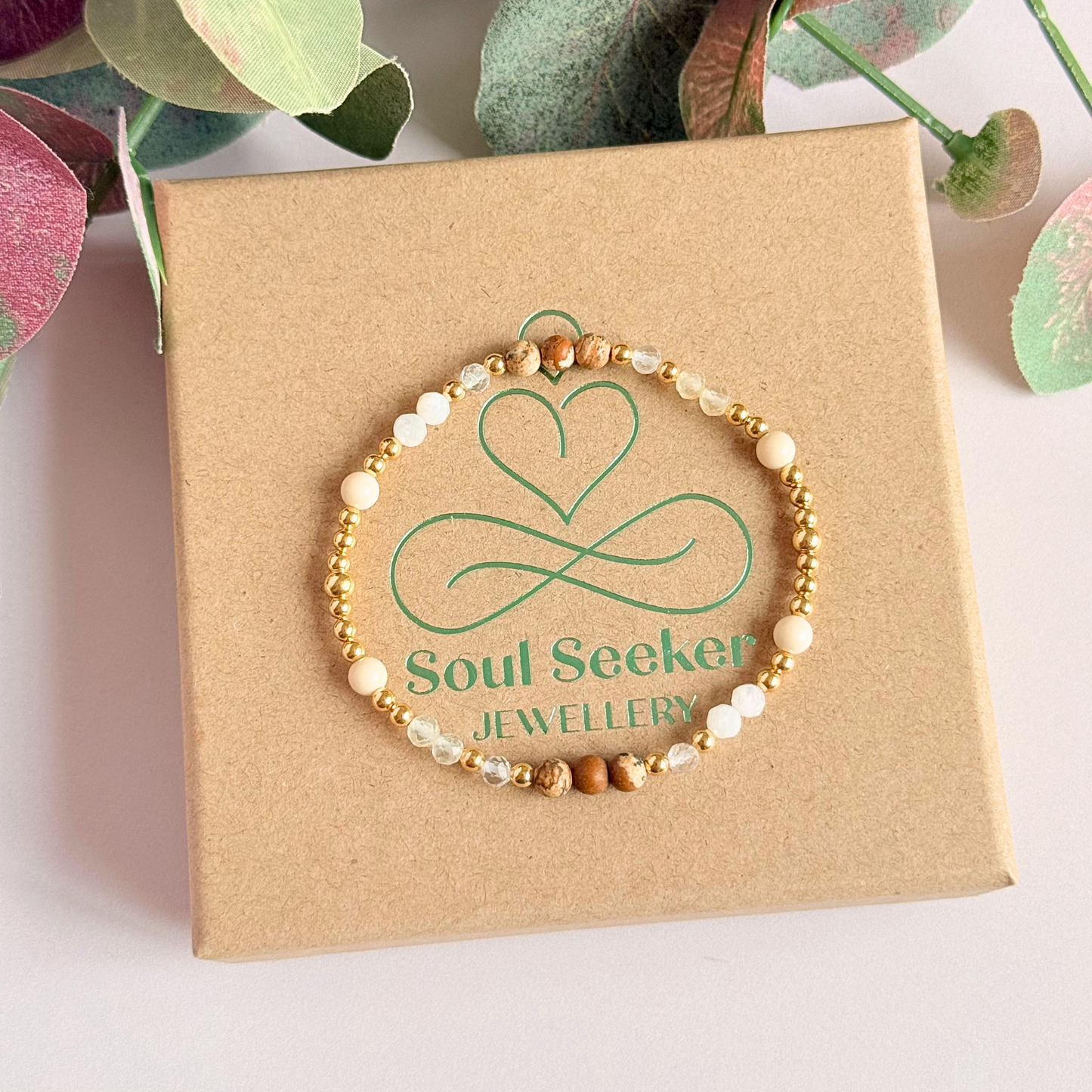 'Ibiza Bohemia' gold vermeil dainty beaded bracelet with picture jasper, river stone jasper, citrine, clear quartz and moonstone. Made with round 3mm gold vermeil beads and 4mm smooth and faceted round crystal gemstone beads. Pictured from above, on top of the gift box.