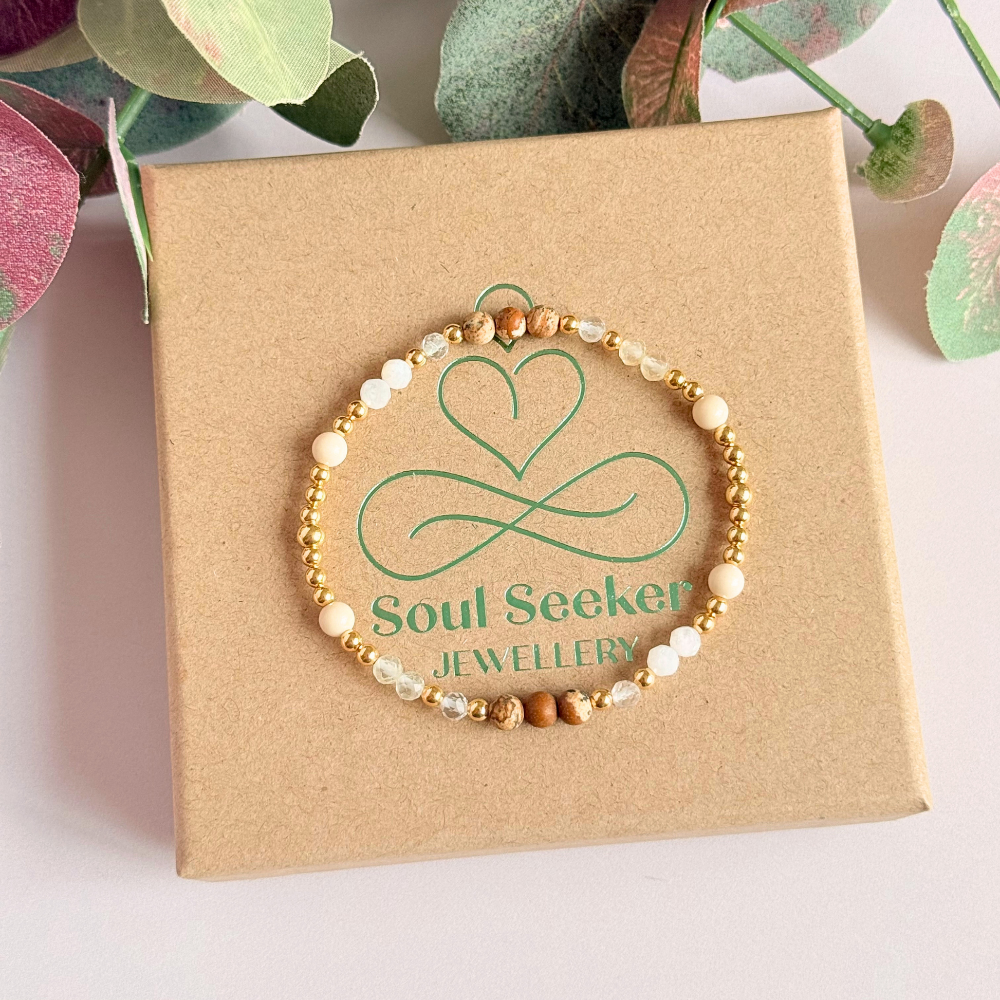 'Ibiza Bohemia' gold vermeil dainty beaded bracelet with picture jasper, river stone jasper, citrine, clear quartz and moonstone. Made with round 3mm gold vermeil beads and 4mm smooth and faceted round crystal gemstone beads. Pictured from above, on top of the gift box.