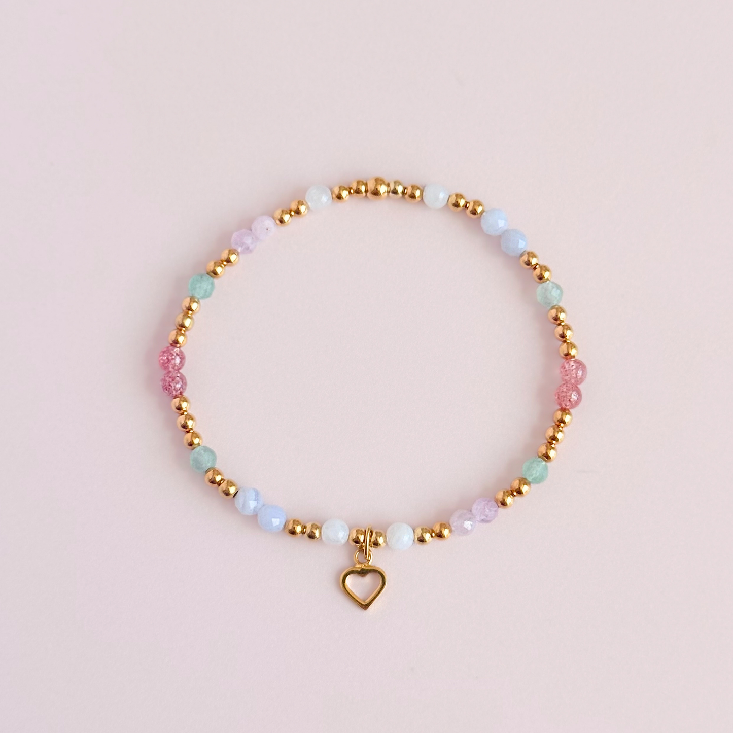 'Soft girl summer' gold vermeil dainty beaded bracelet with Kunzite, moonstone, green aventurine, blue lace agate and strawberry quartz . With a beautiful open heart charm.Made with round 3mm gold vermeil beads and 4mm smooth and faceted round crystal gemstone beads. Pictured from above, against a pink background