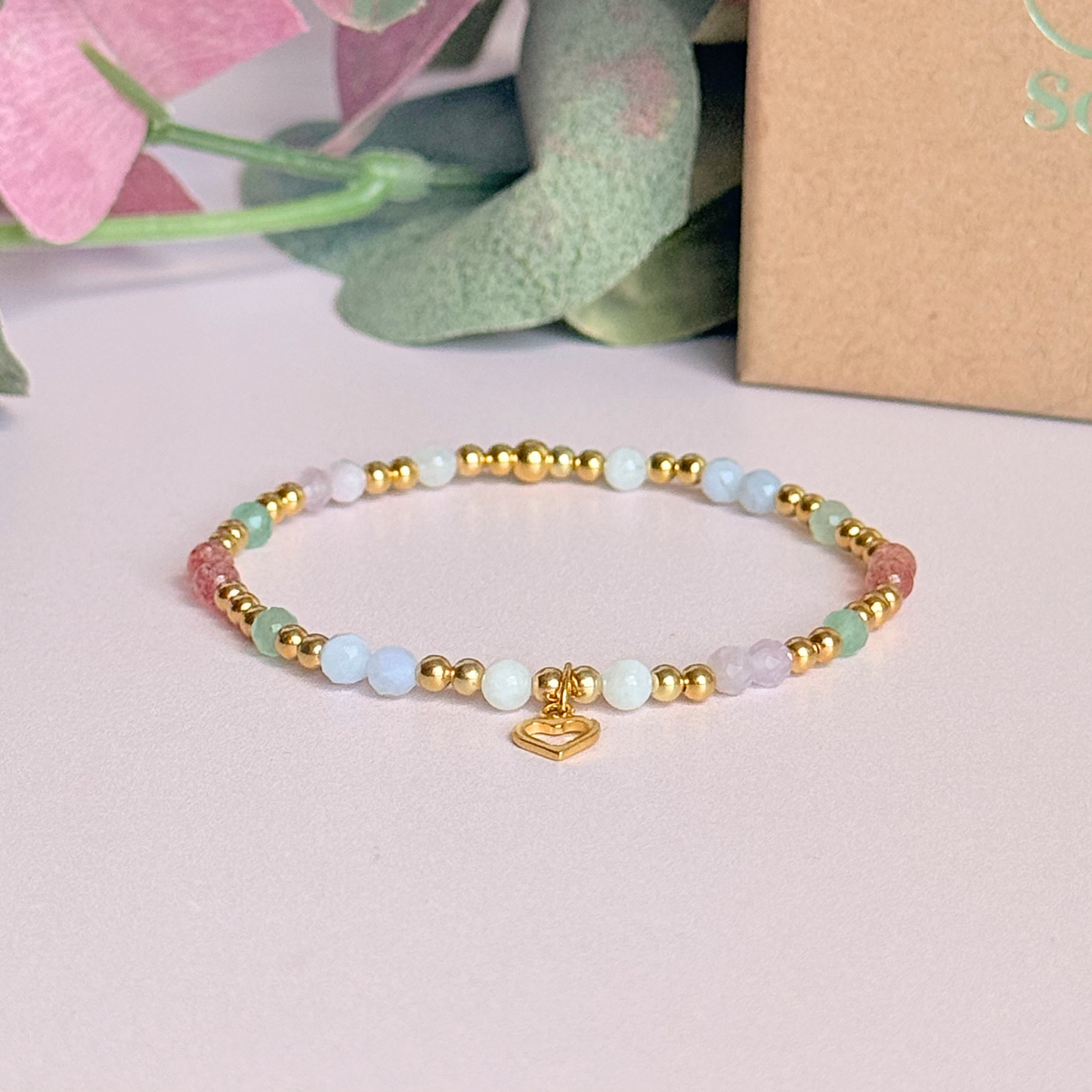 'Soft girl summer' gold vermeil dainty beaded bracelet with Kunzite, moonstone, green aventurine, blue lace agate and strawberry quartz . With a beautiful open heart charm.Made with round 3mm gold vermeil beads and 4mm smooth and faceted round crystal gemstone beads. Pictured in front of the gift box