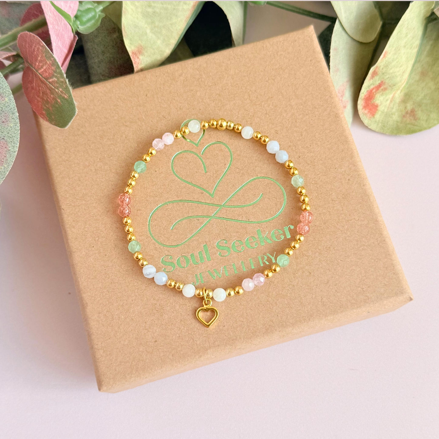 'Soft girl summer' gold vermeil dainty beaded bracelet with Kunzite, moonstone, green aventurine, blue lace agate and strawberry quartz . With a beautiful open heart charm.Made with round 3mm gold vermeil beads and 4mm smooth and faceted round crystal gemstone beads. Pictured from above, on the box