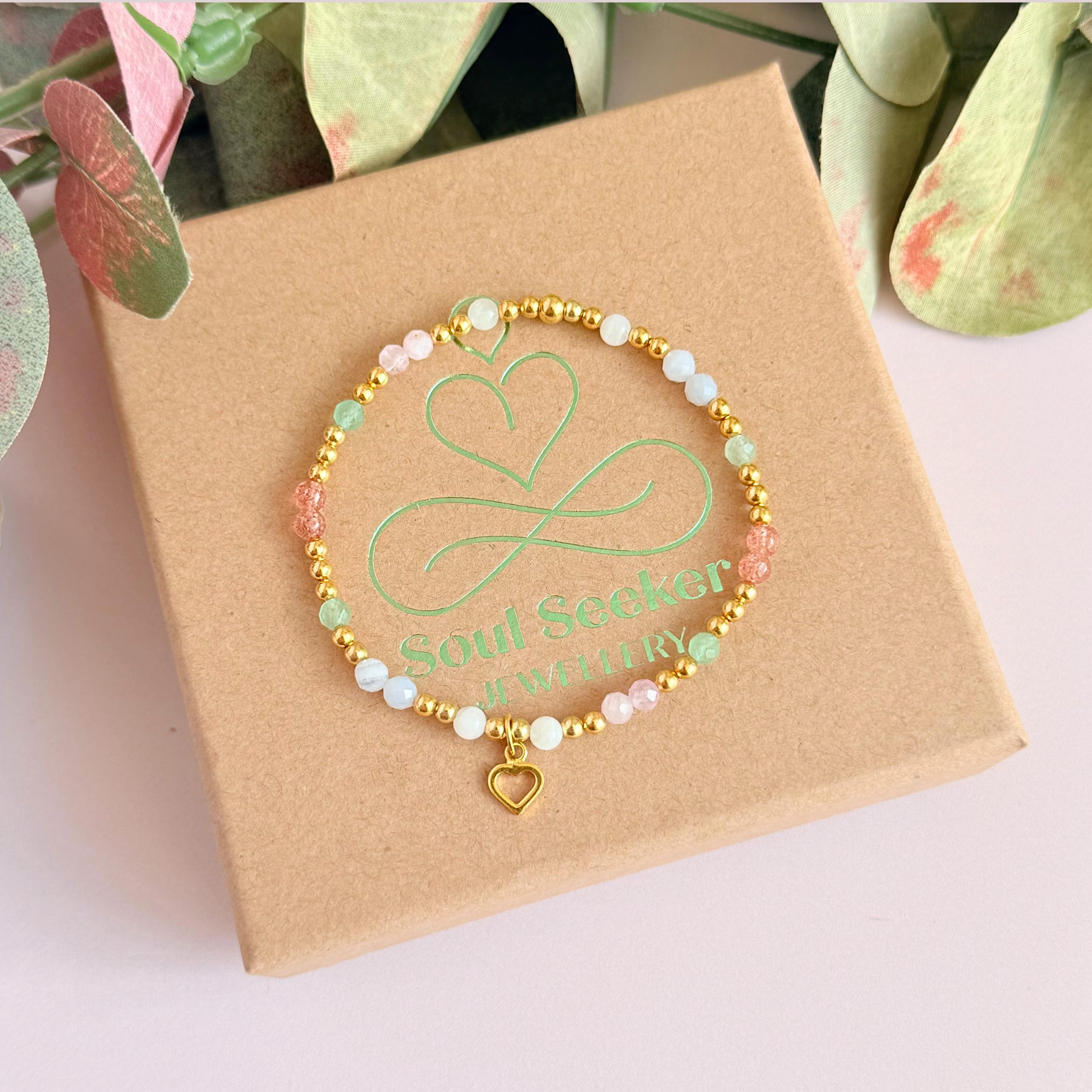 'Soft girl summer' gold vermeil dainty beaded bracelet with Kunzite, moonstone, green aventurine, blue lace agate and strawberry quartz . With a beautiful open heart charm.Made with round 3mm gold vermeil beads and 4mm smooth and faceted round crystal gemstone beads. Pictured from above, on the box