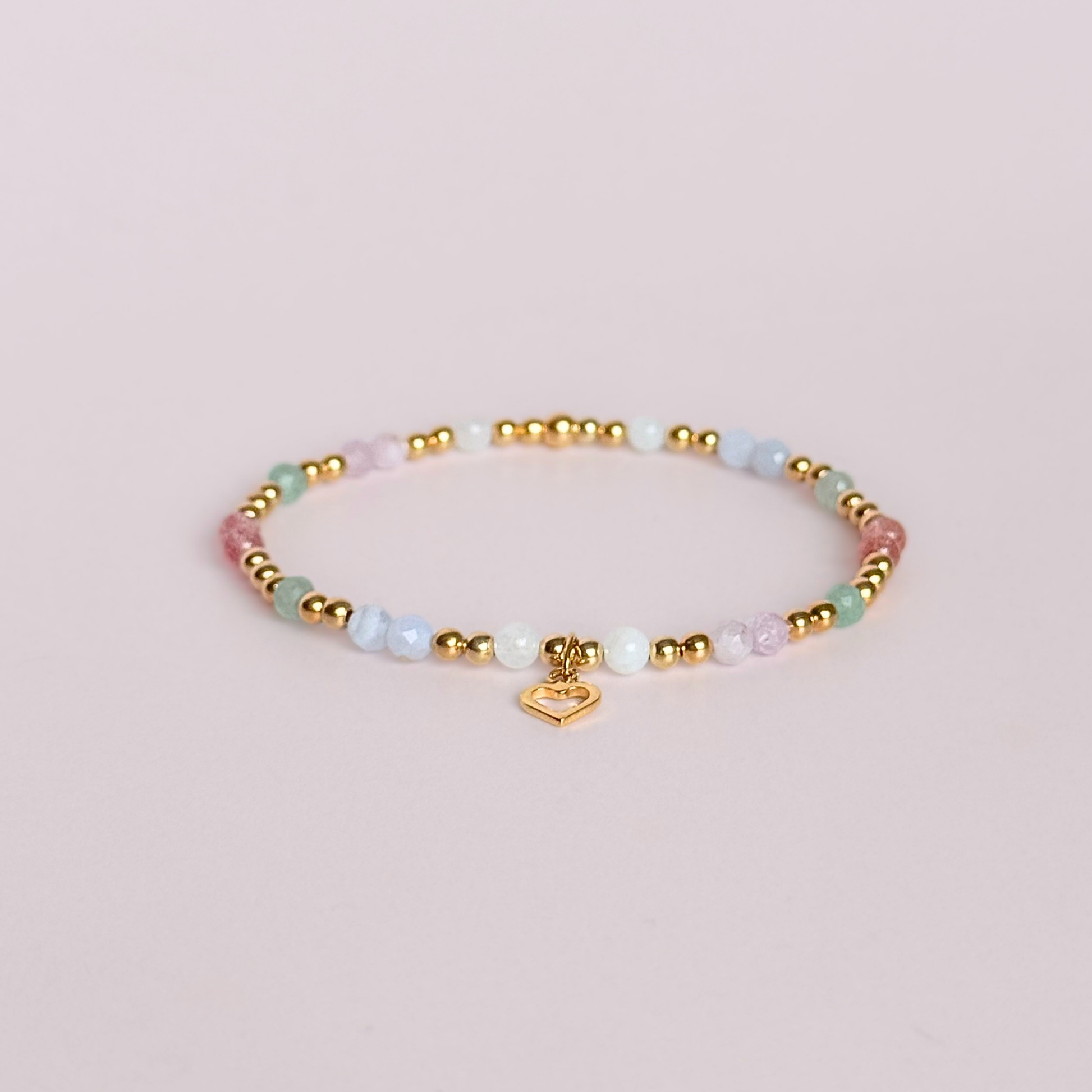 'Soft girl summer' gold vermeil dainty beaded bracelet with Kunzite, moonstone, green aventurine, blue lace agate and strawberry quartz . With a beautiful open heart charm.Made with round 3mm gold vermeil beads and 4mm smooth and faceted round crystal gemstone beads. Pictured on a pink background