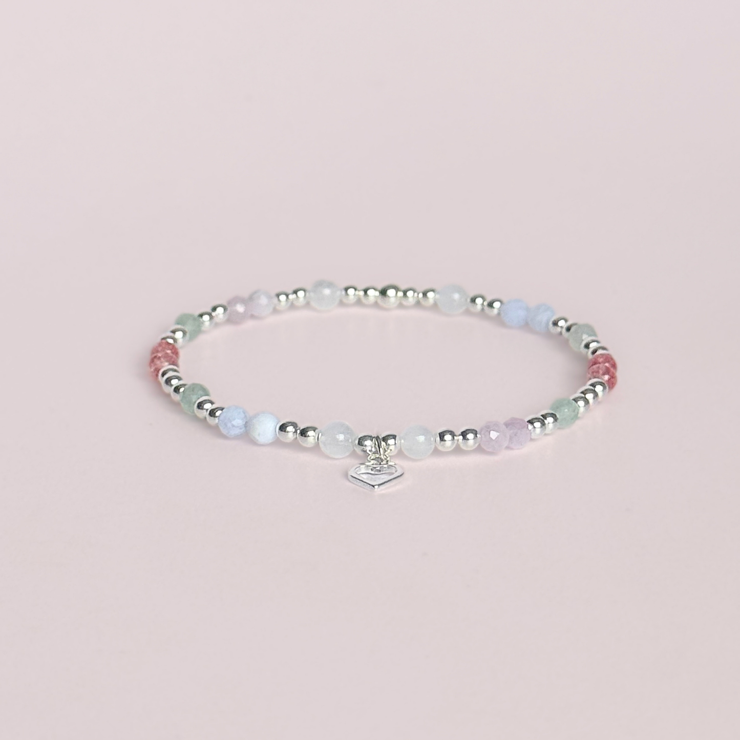 'Soft girl summer' sterling silver dainty beaded bracelet with Kunzite, moonstone, green aventurine, blue lace agate and strawberry quartz . With a beautiful open heart charm.Made with round 3mm sterling silver beads and 4mm smooth and faceted round crystal gemstone beads. Pictured against a pink background