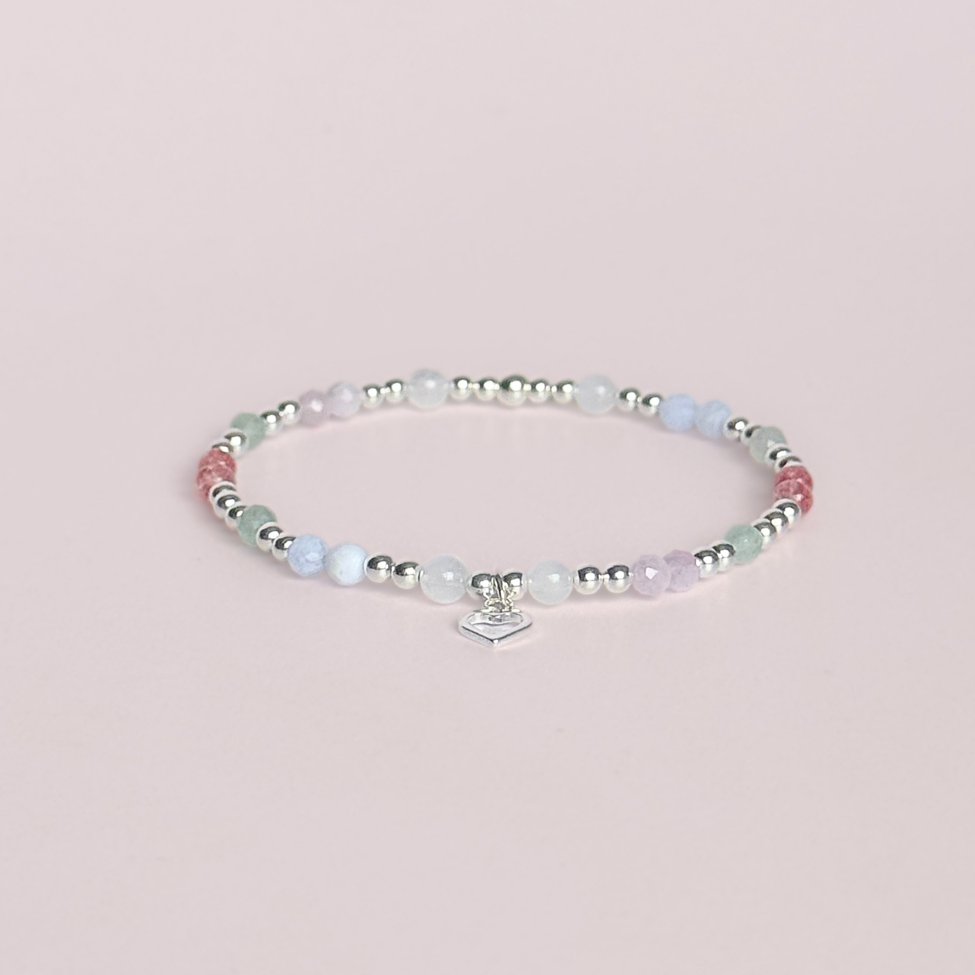 'Soft girl summer' sterling silver dainty beaded bracelet with Kunzite, moonstone, green aventurine, blue lace agate and strawberry quartz . With a beautiful open heart charm.Made with round 3mm sterling silver beads and 4mm smooth and faceted round crystal gemstone beads. Pictured against a pink background