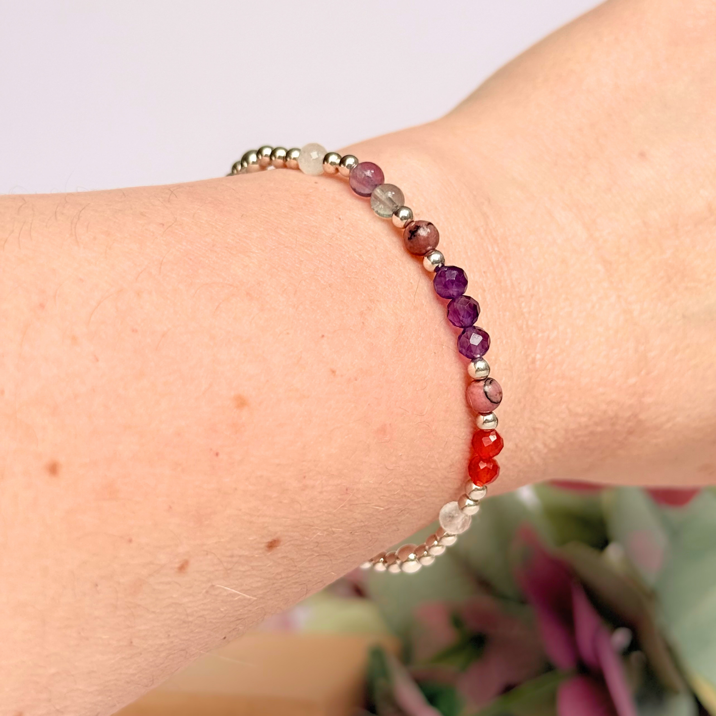 Dainty sterling silver crystal bracelet featuring five crystals, in 4mm faceted and smooth round style, each believed to help with perimenopause symptoms. Featuring amethyst, rhodonite, fluorite, moonstone and carnelian. Pictured being worn.