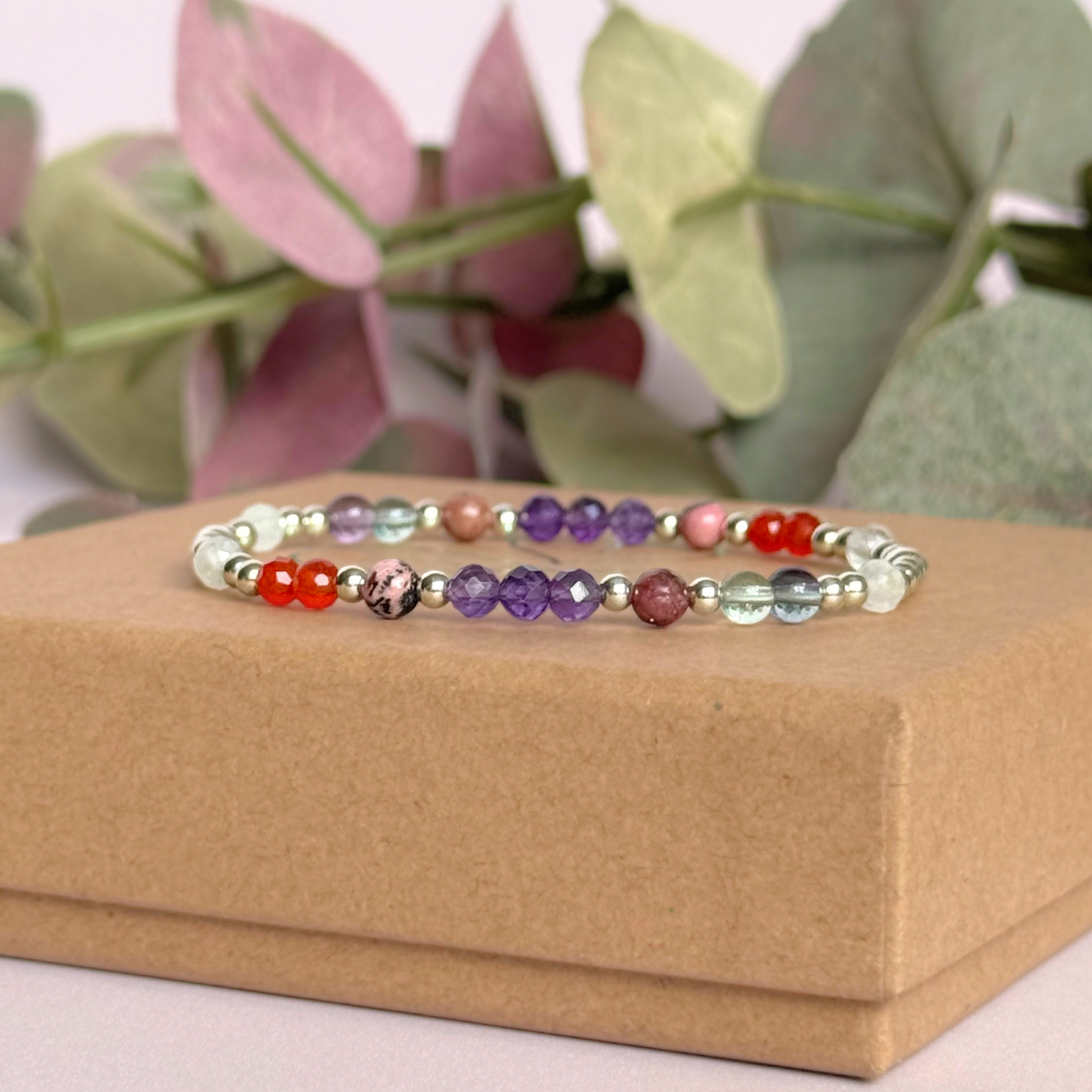 Dainty sterling silver crystal bracelet featuring five crystals, in 4mm faceted and smooth round style, each believed to help with perimenopause symptoms. Featuring amethyst, rhodonite, fluorite, moonstone and carnelian. Pictured on top of the gift box.