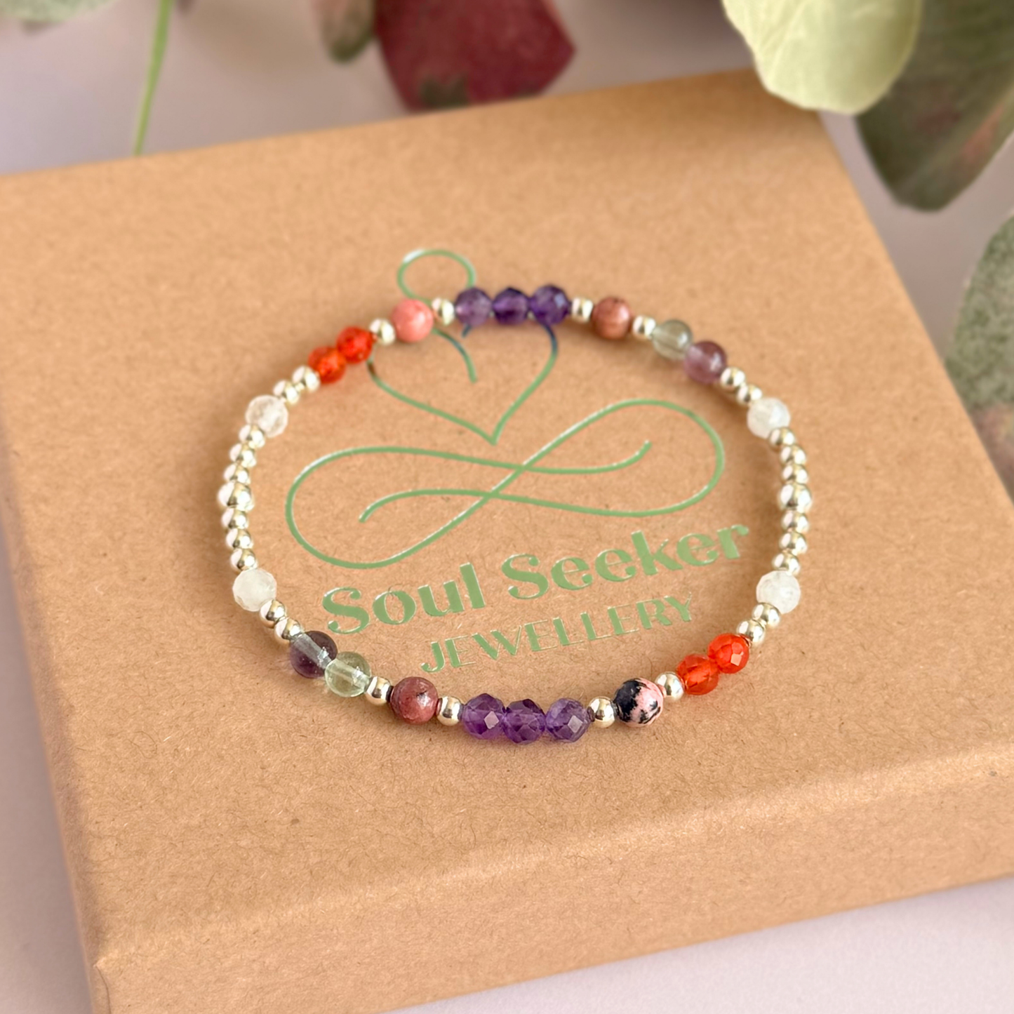 Dainty sterling silver crystal bracelet featuring five crystals, in 4mm faceted and smooth round style, each believed to help with perimenopause symptoms. Featuring amethyst, rhodonite, fluorite, moonstone and carnelian. Pictured on top of the gift box.