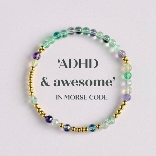 Elasticated stretch fluorite crystal morse code bracelet spelling out the words ‘ADHD and awesome’ in a combination of 4mm round fluorite beads, 4mm faceted fluorite beads and either sterling silver or gold vermeil 3mm round beads. The words start and end at the rondelle spacer beads.