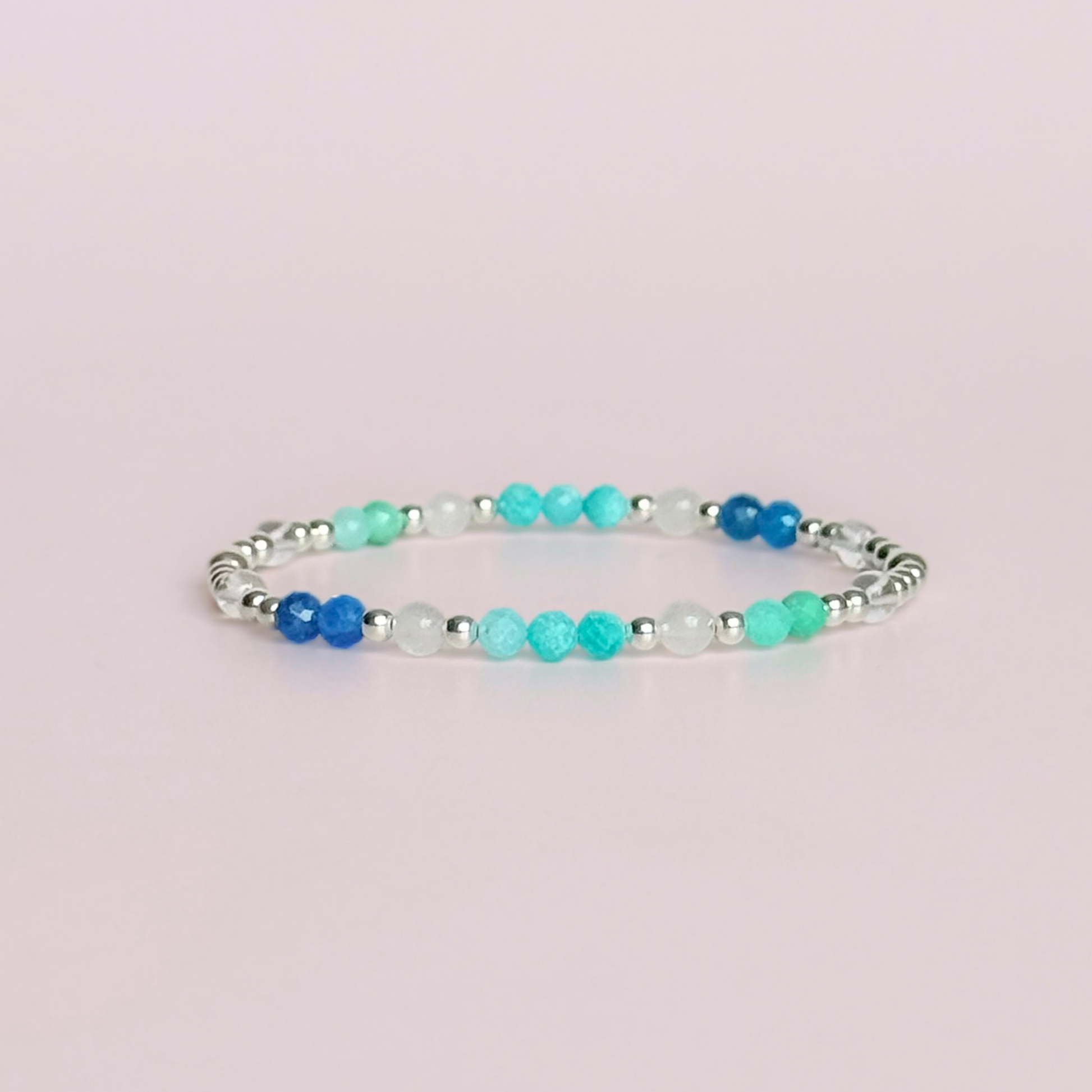 ‘Caribbean Dream' sterling silver dainty beaded bracelet with white jade, chrysoprase, amazonite, apatite and clear quartz. Made with round 3mm sterling silver beads and 4mm smooth and faceted round crystal gemstone beads. Pictured against a pink background