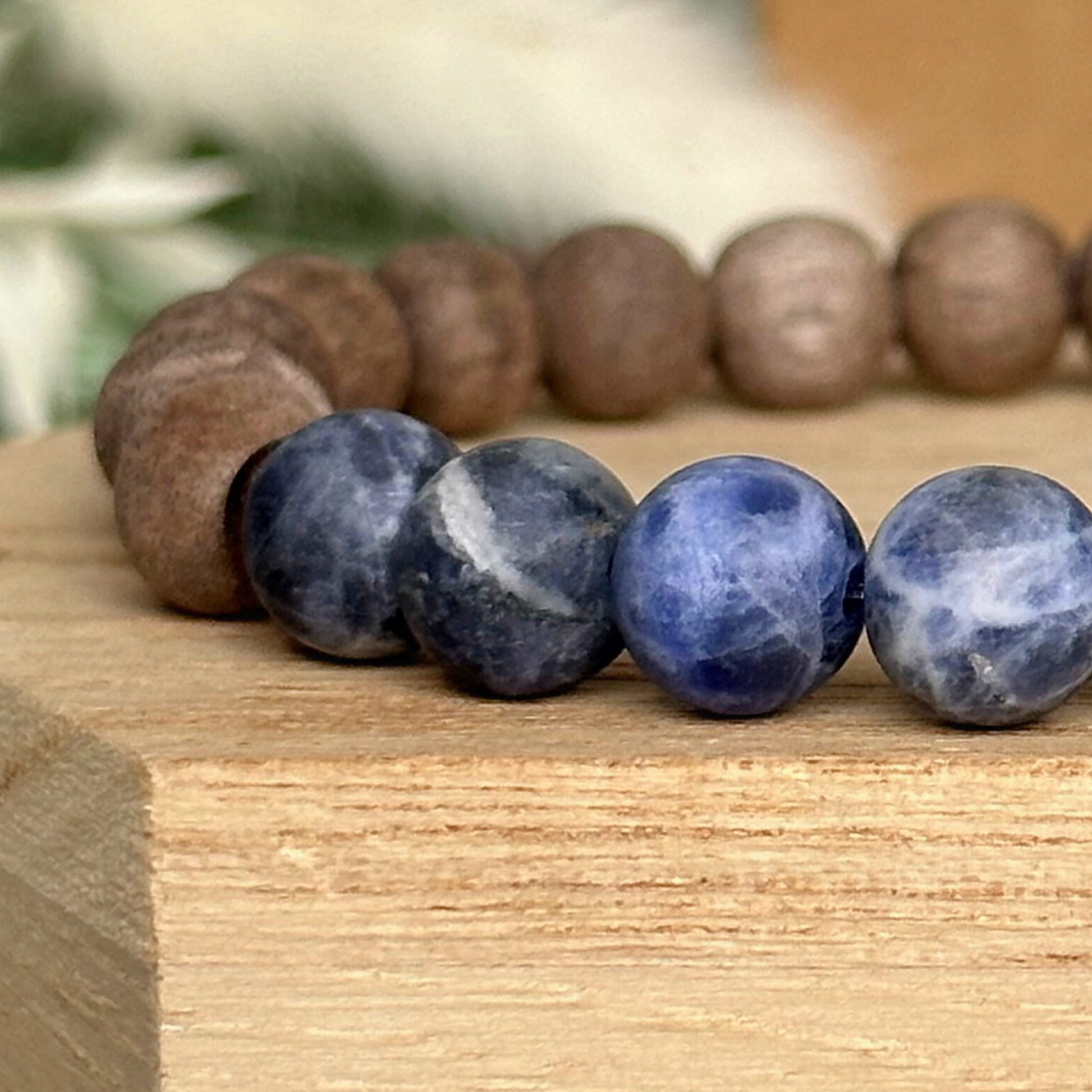 Mens crystal healing bracelet featuring 8mm frosted sodalite beads, grey wood beads and sandalwood spacer beads.