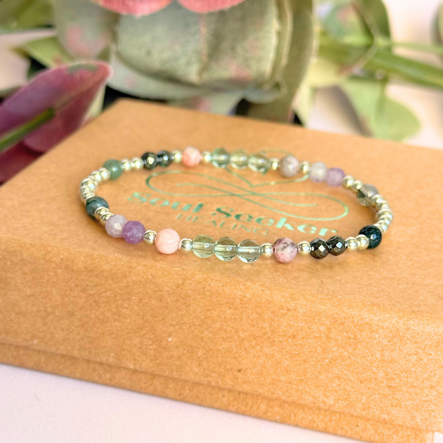Dainty crystal bracelet featuring five crystals all believed to help with focus, clarity and overwhelm. Featuring fluorite, hematite, lepidolite, moss agate and pink zebra jasper. Featuring 3mm sterling silver round beads and 4mm faceted round and smooth round crystal beads. Pictured on top of the gift box.